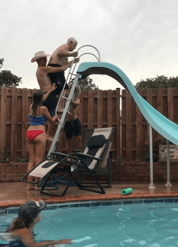 Family members helping Roy Beller up the stairs to the waterslide. | Photo: Facebook/MichaelandMichelle Graham