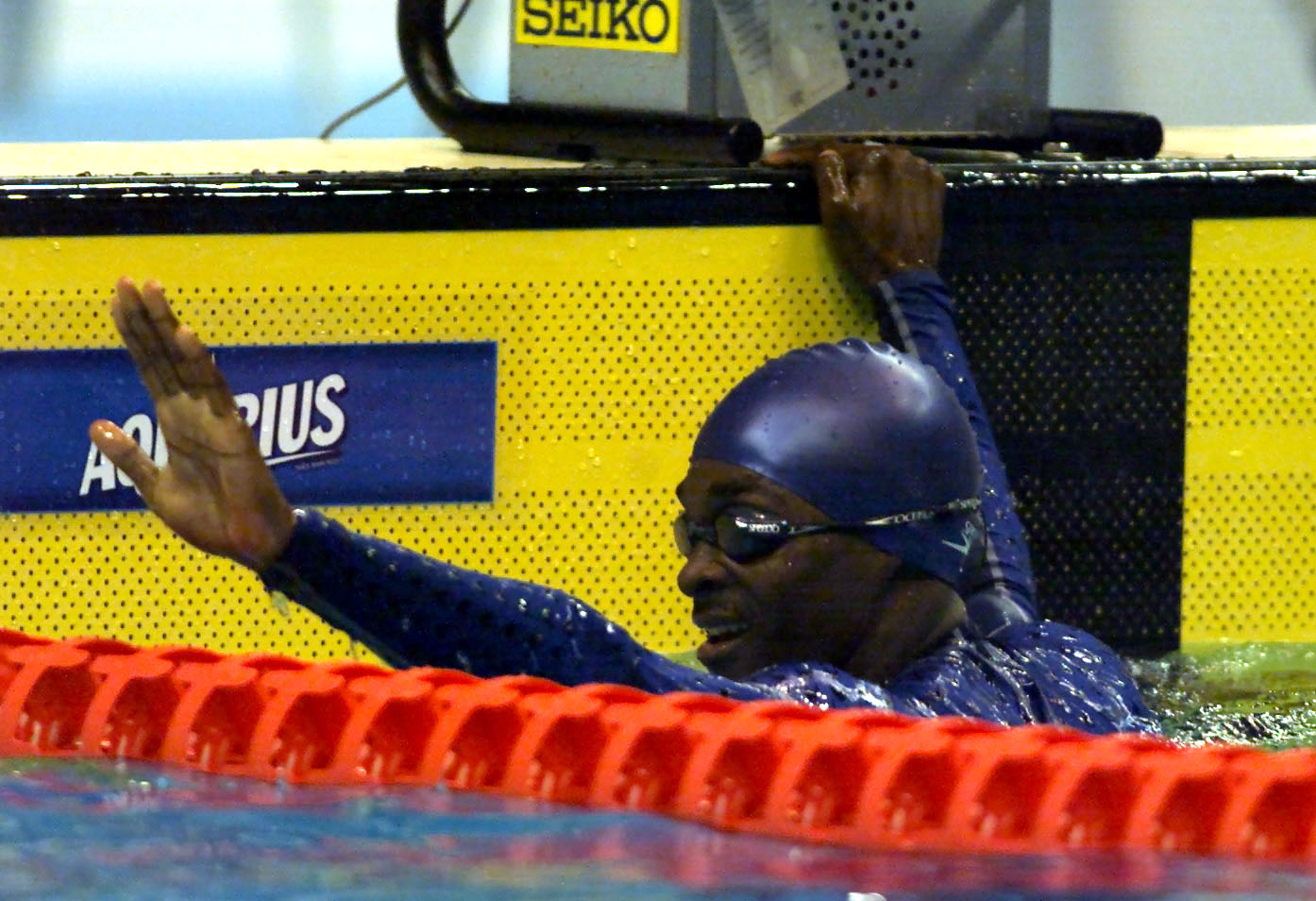 Eric Moussambani waves to the crowd after the men's 50m Freestyle heats during the World Swimming Championships, on July 22, 2001, in Fukuoka, Japan | Source: Getty Images