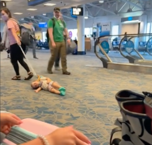 Eine Frau schleppt ein Kind durch den Flughafen. | Quelle: tiktok.com/cacadoodledoo83