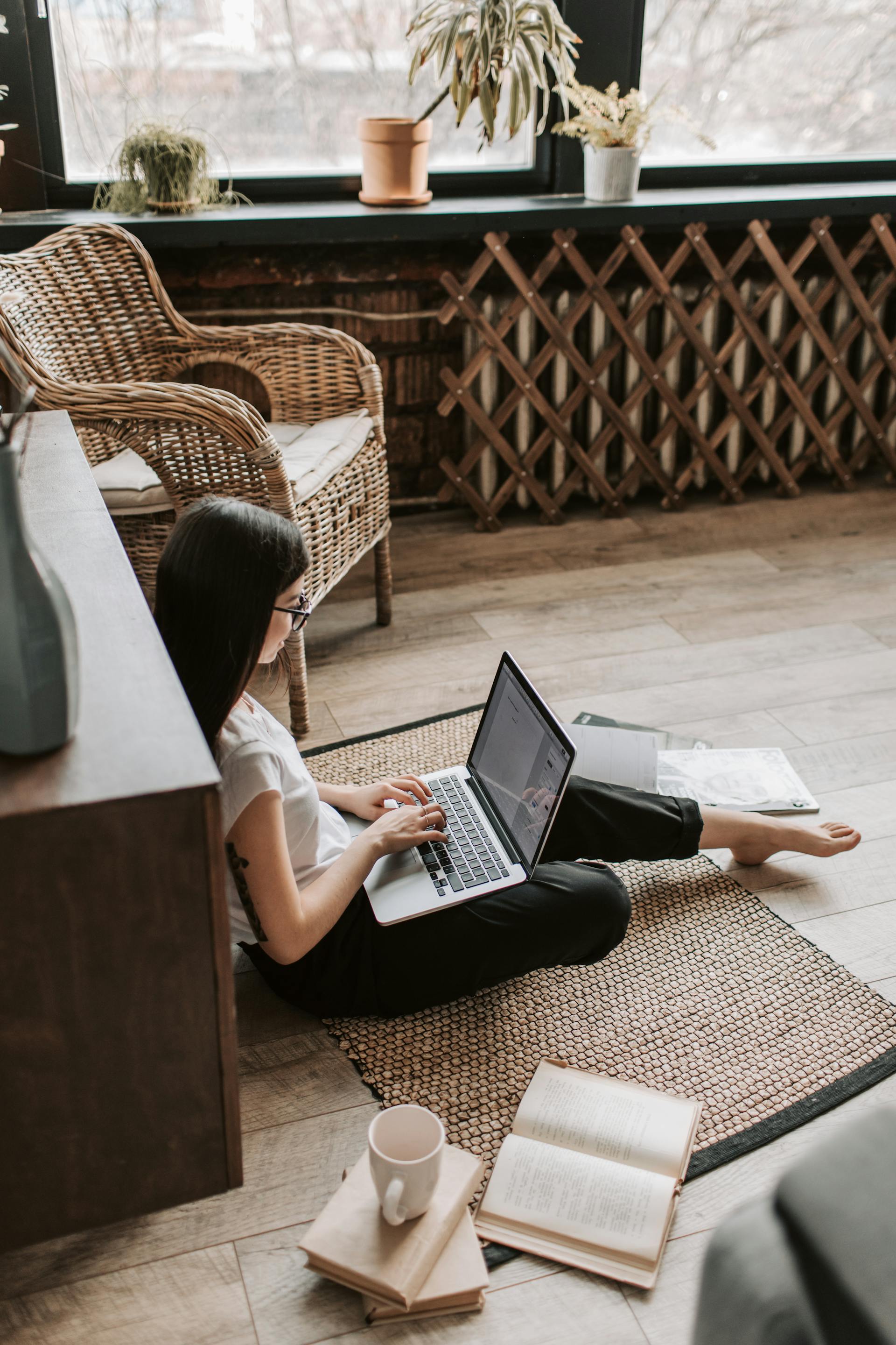 A person sitting on floor using a laptop | Source: Pexels