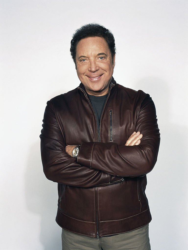 Musician Tom Jones posing wearing a leather jacket paired with a t-shirt and beige pants in 1995. / Source: Getty Images