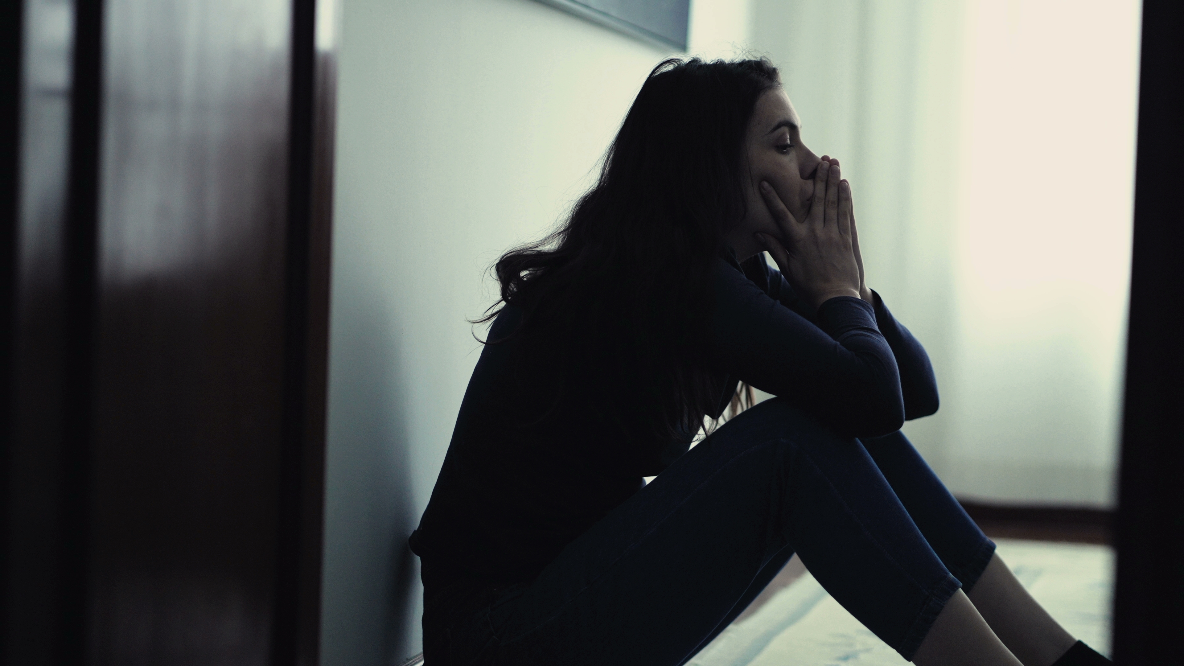 A depressed young woman sitting alone | Source: Shutterstock