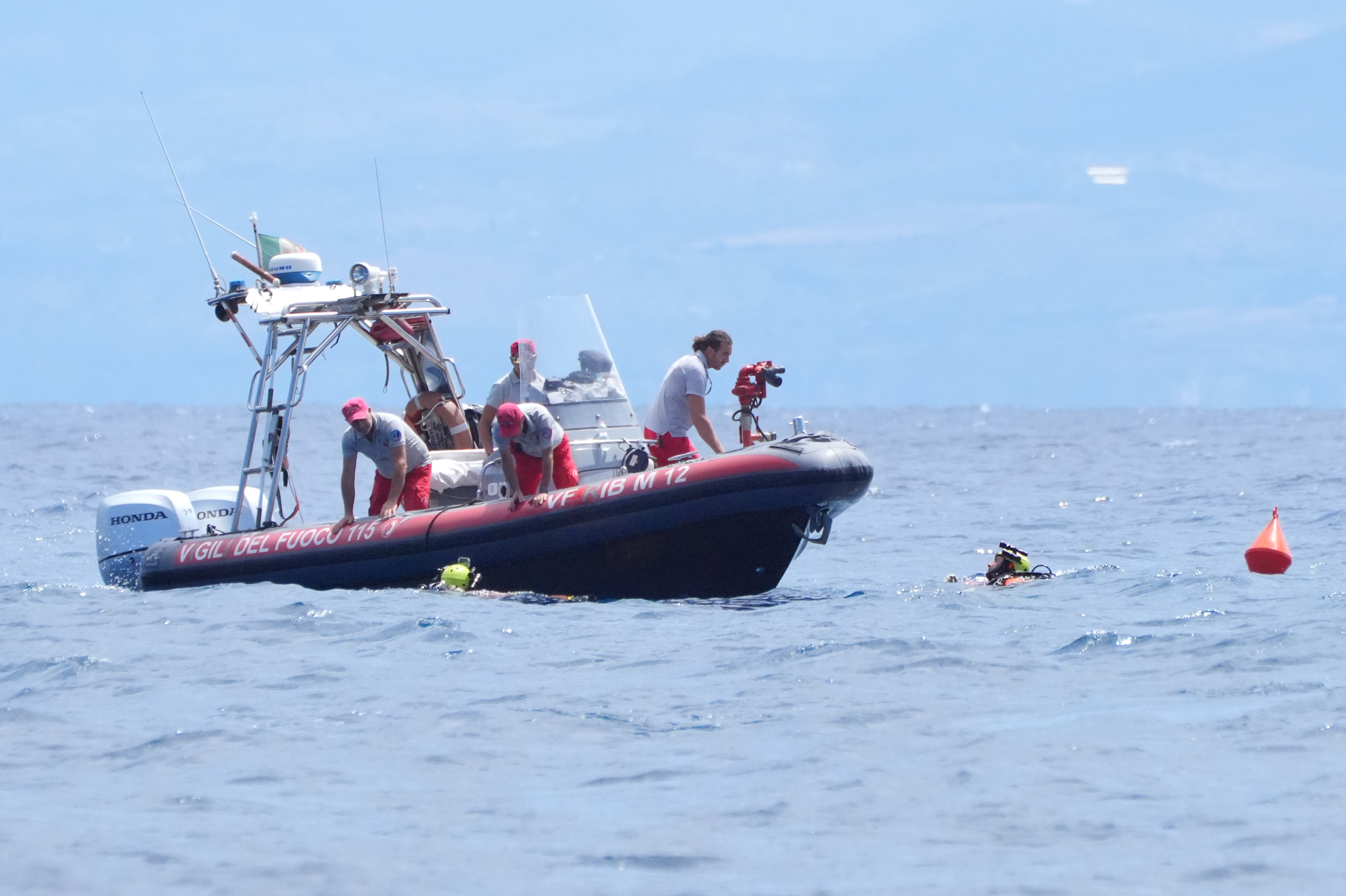 An Italian fire service diving crew surface at their rigid inflatable boat (RiB) from the dive site off the coast of Porticello, Sicily on August 21, 2024 | Source: Getty Images