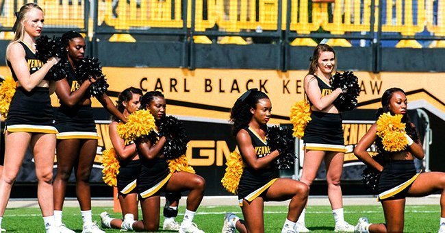 Tommia Dean and 4 other cheerleaders kneeling during a football game at KSU | Source: Twitter/wsbtv
