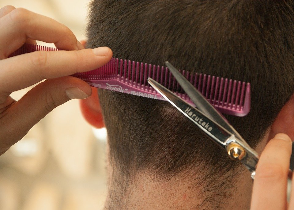 Estilista realizando un corte de cabello a una mujer. | Foto: Pixabay