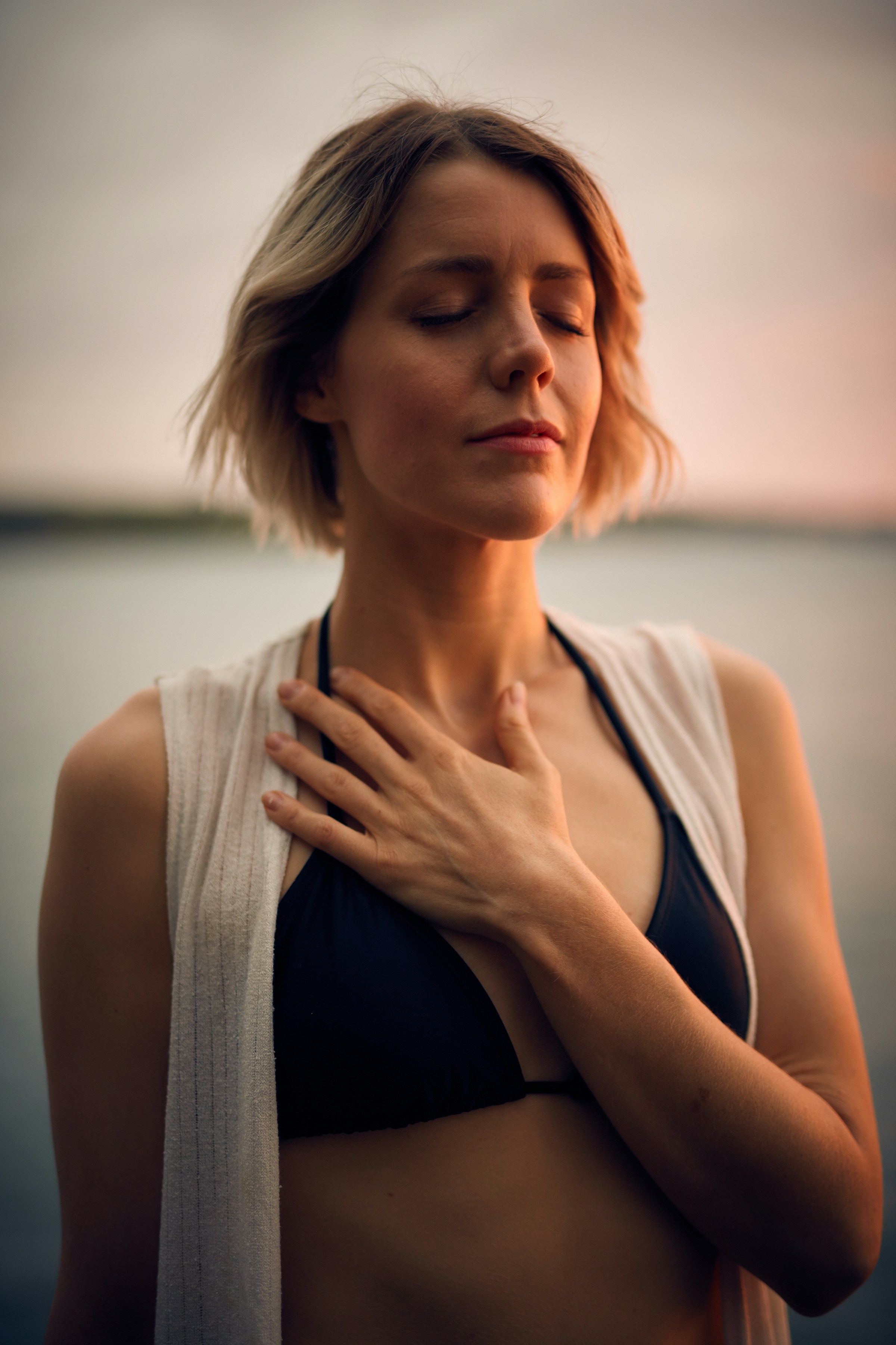 A woman standing outdoors with a hand on her chest | Source: Unsplash