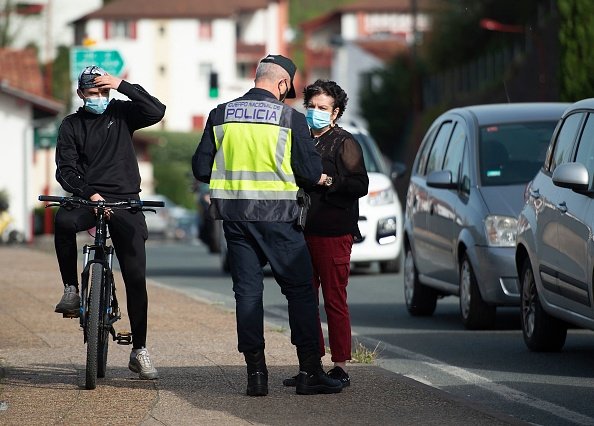 Un policier un piéton au point de contrôle. |Photo : Getty Images