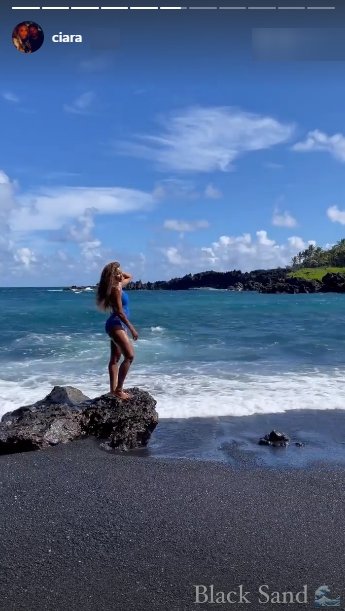 Ciara, dressed in a blue swimsuit and standing on a rock close to the ocean | Photo: Instagram/ciara