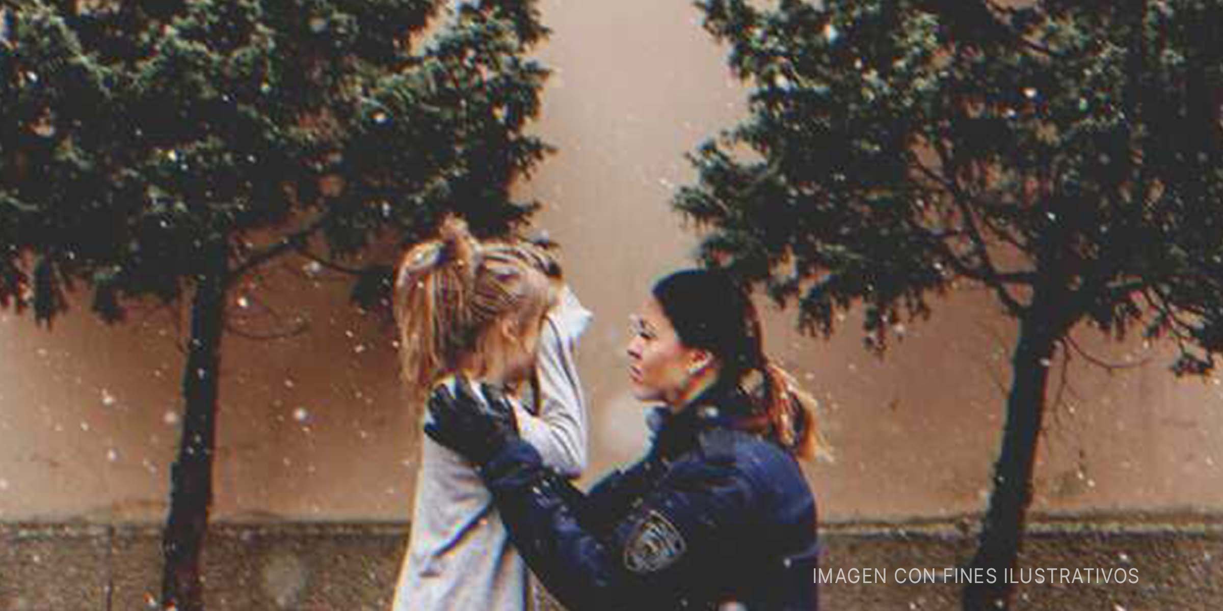 Mujer policía consolando a una niña triste. | Foto: Getty Images | Shutterstock