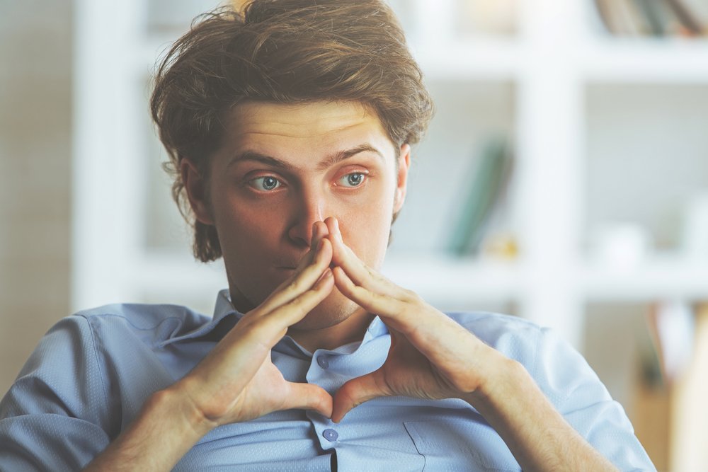 A photo of a worried man with his hands together. | Photo: Shutterstock