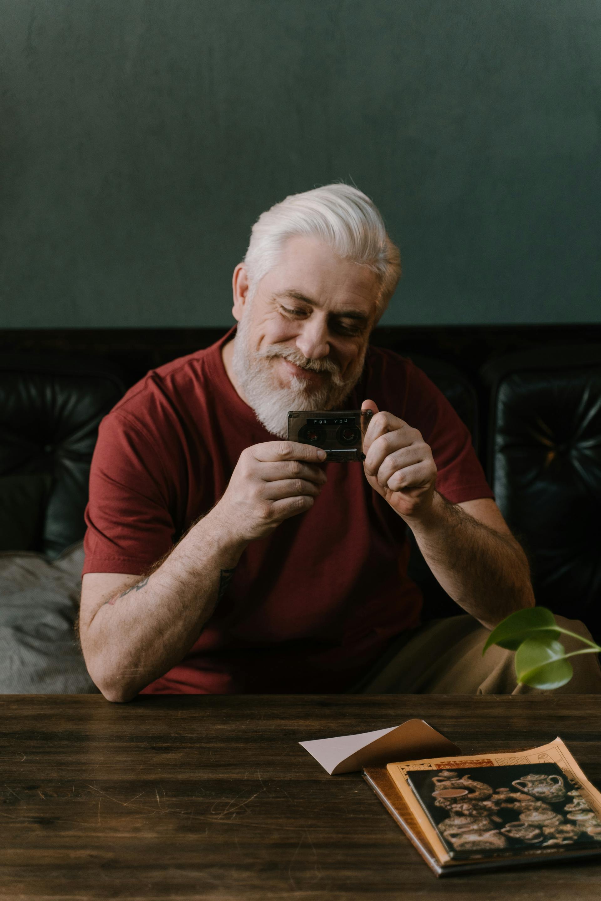 A smiling older man looking at a card | Source: Pexels