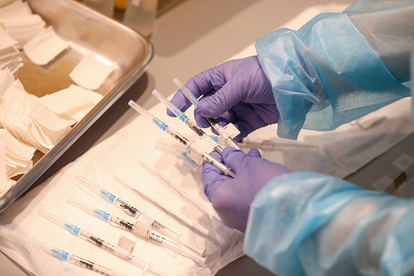 Un employé du secteur de la santé tient un des vaccins Covid-19. | Photo : Getty Images