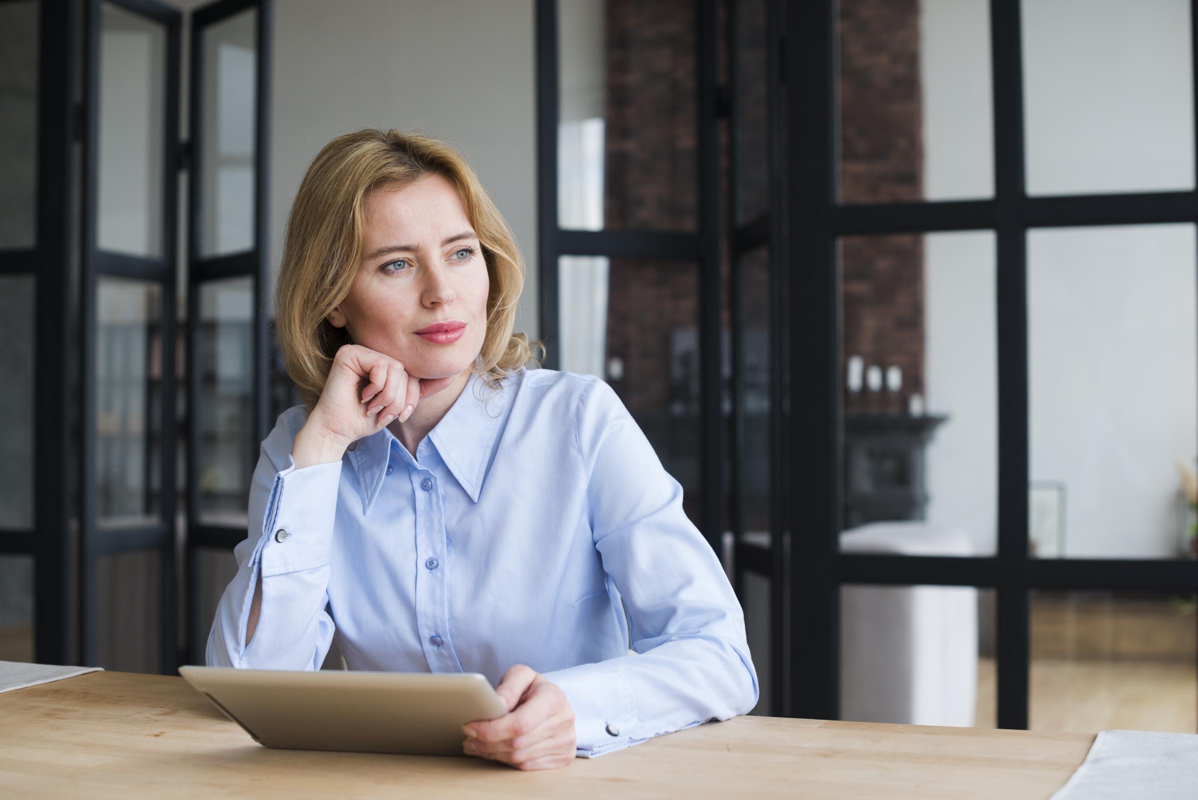 A woman sitting at a table | Source: Freepik