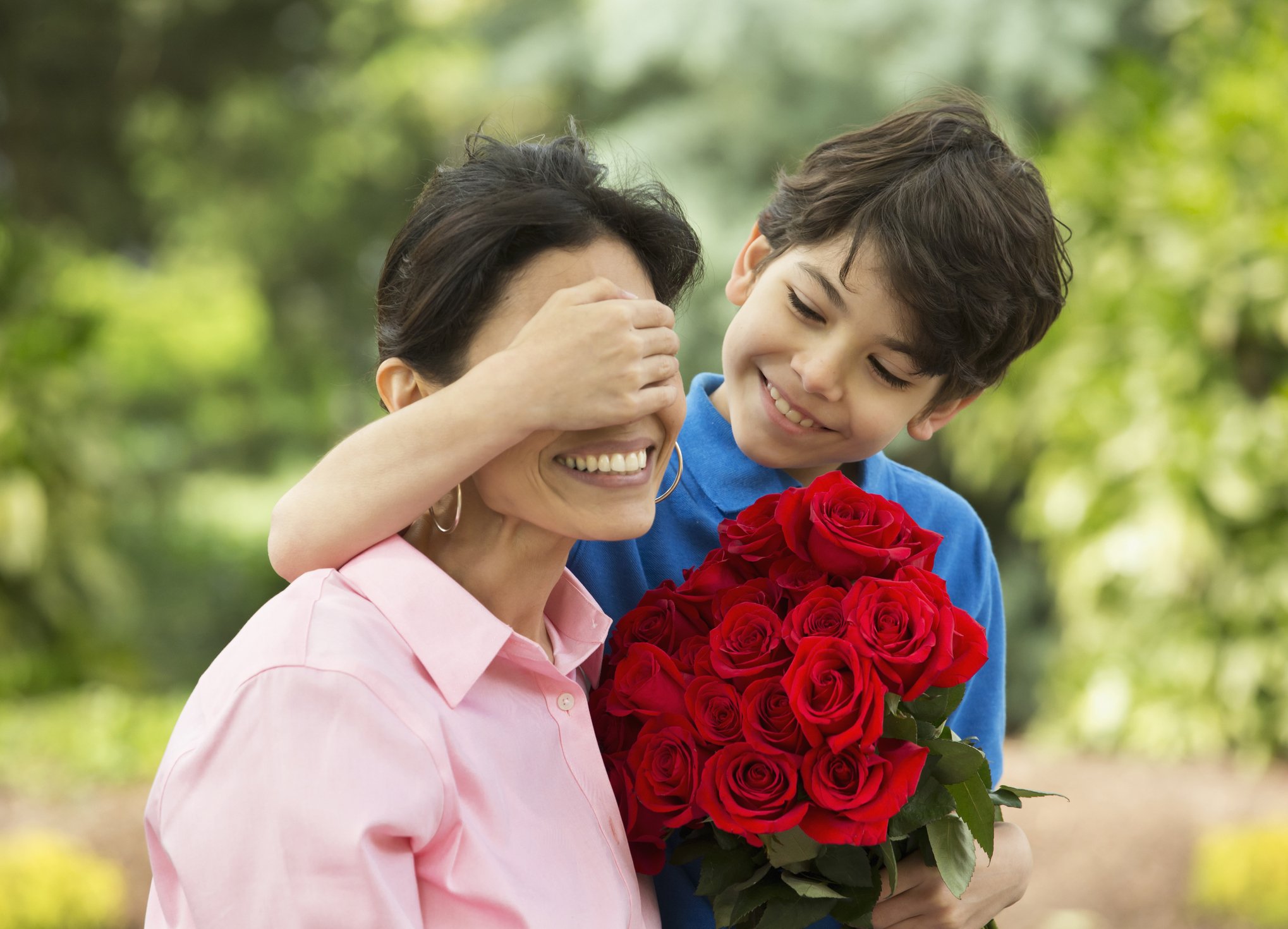 Hispanic boy giving mother bouquet of roses | Photo: Getty Images