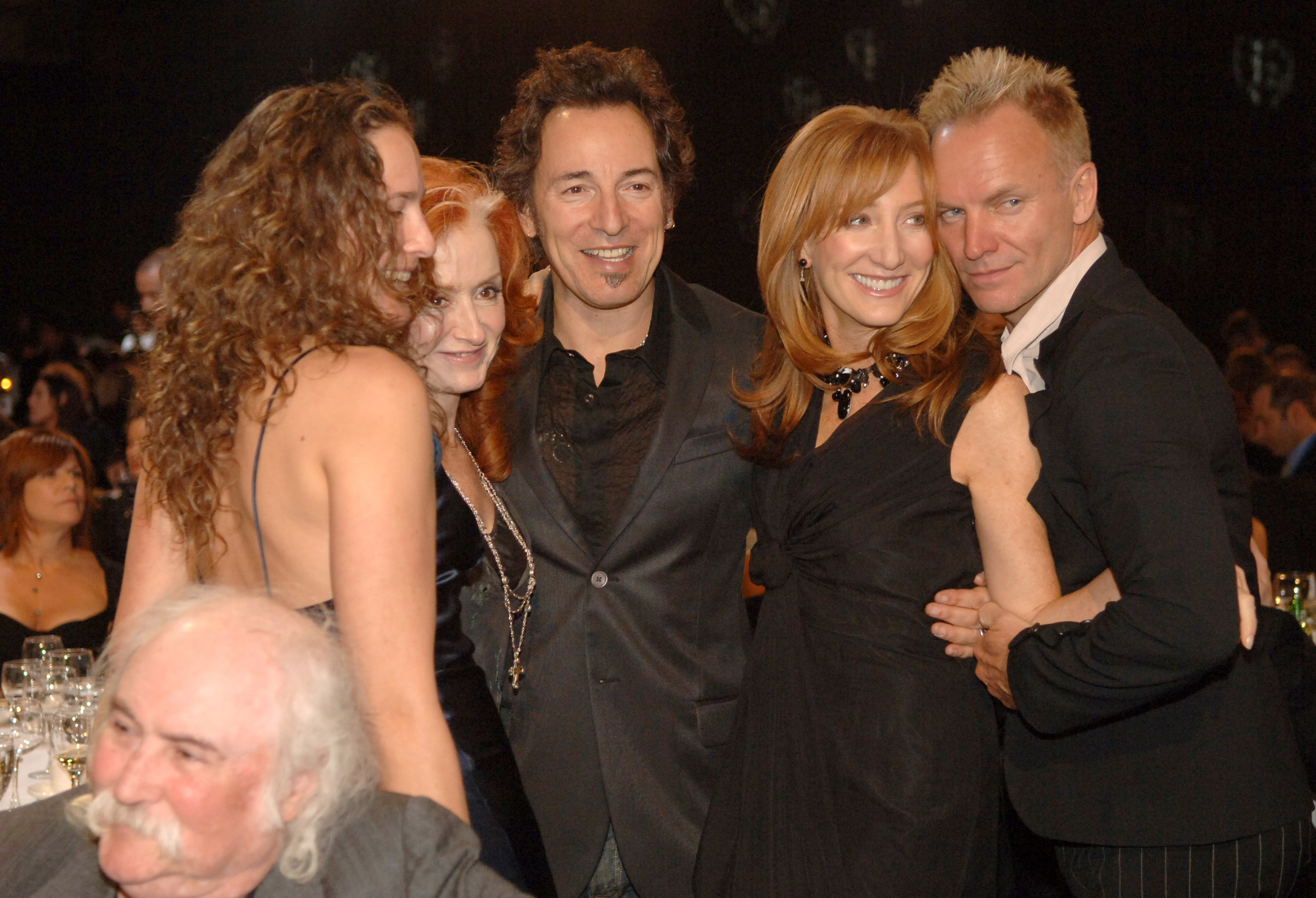 At the 2006 MusiCares Person of the Year event honoring James Taylor, Trudie Styler, Bruce Springsteen, Sting, and Patti Scialfa are captured backstage sharing smiles. The photo highlights a close-knit circle of friends brought together by music, legacy, and mutual respect.