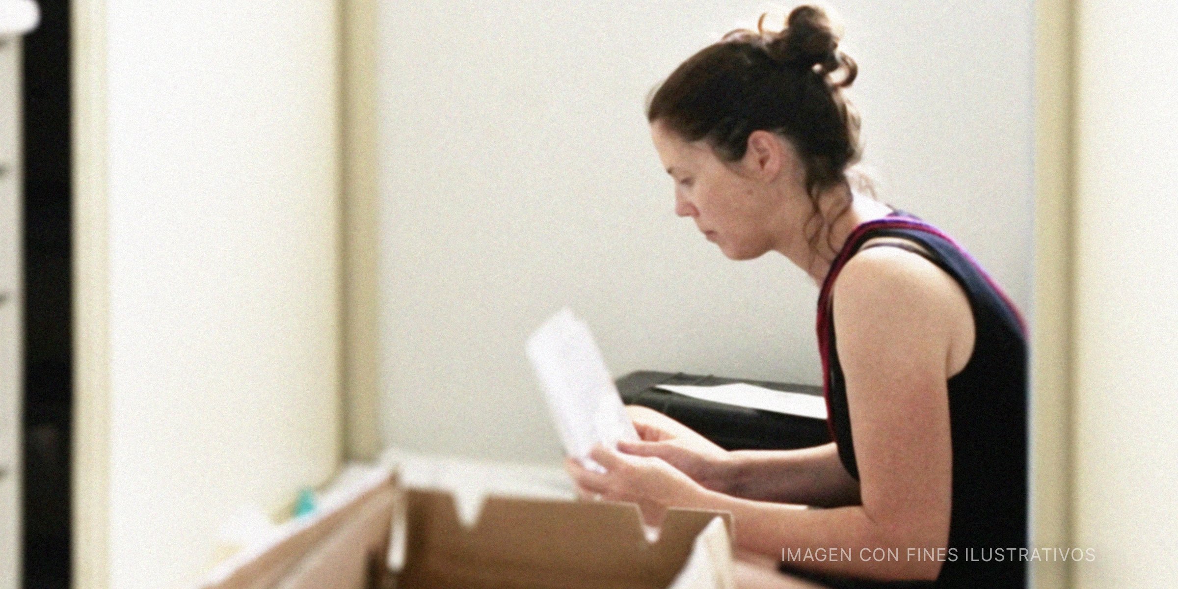 Mujer leyendo una carta encontrada en una caja. | Foto: Getty Images