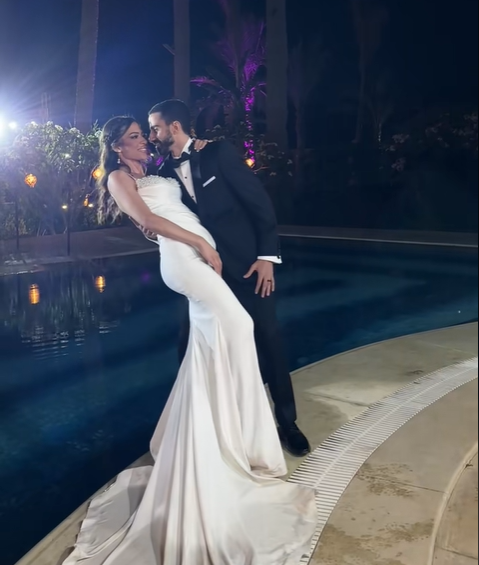 The bride and groom. The groom supports his bride with his hands as she leans into it, from a July 2025 video post | Source: TikTok/emadjoe1