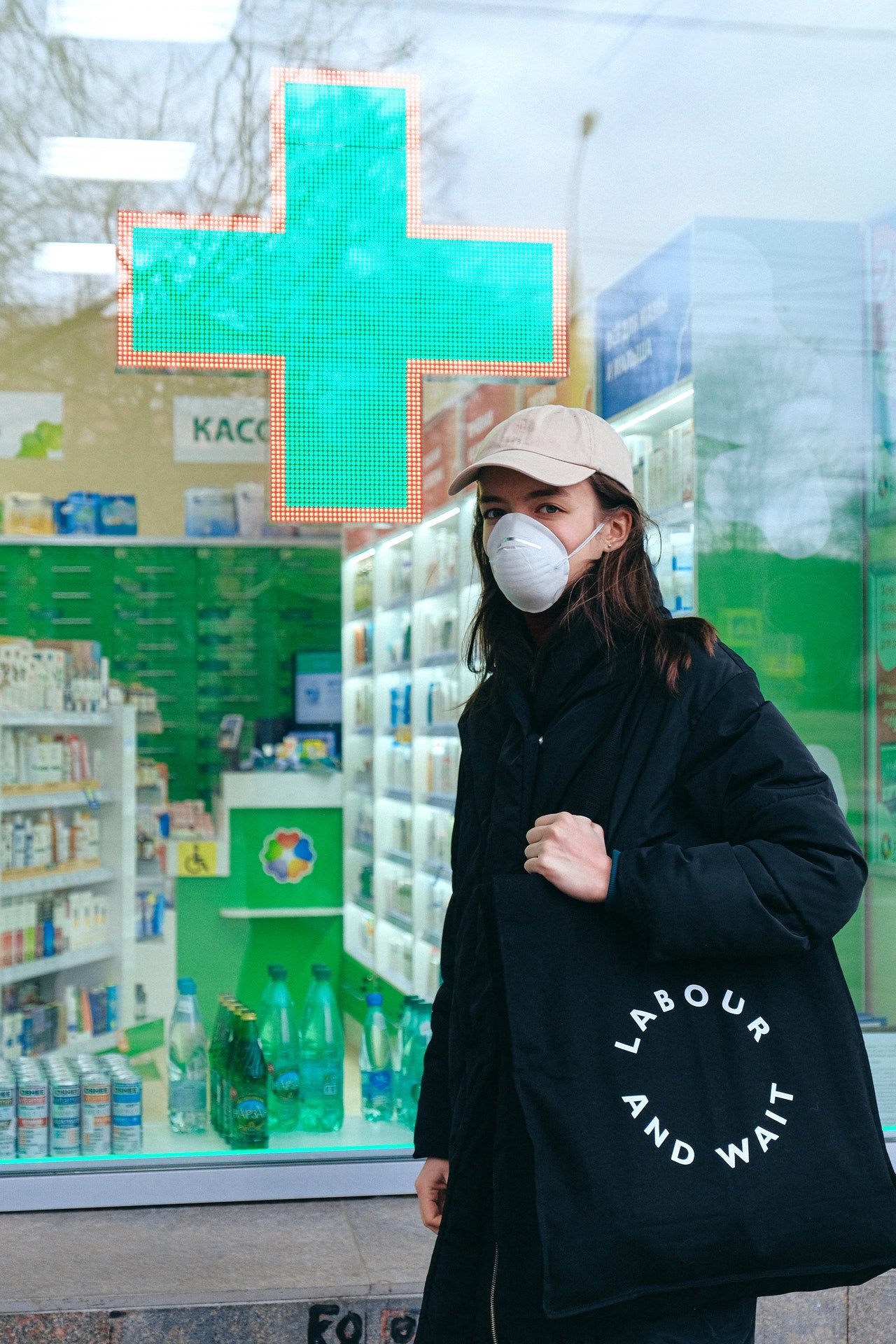 Photo of woman standing in front of a pharmacy store | Photo: Pexels