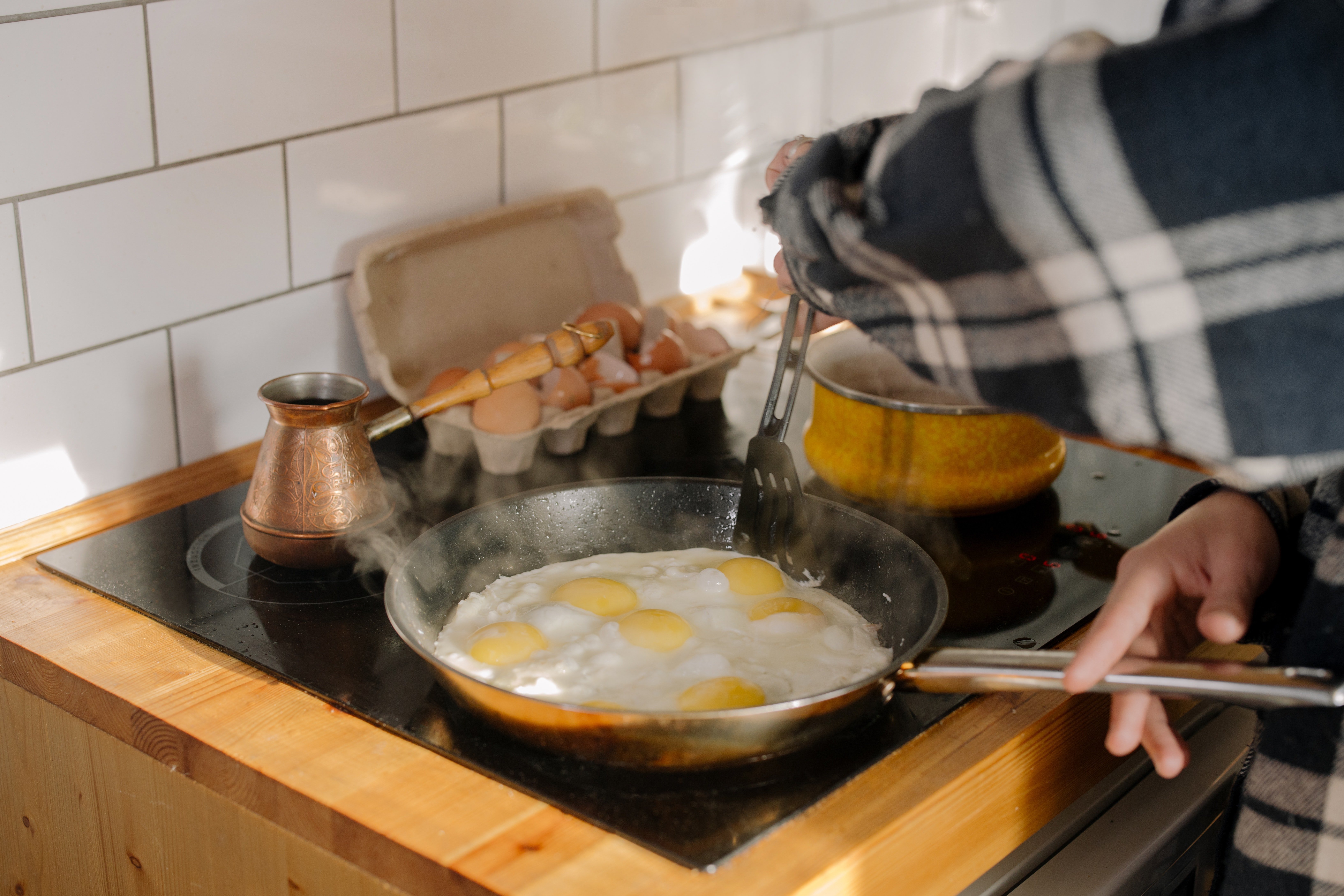 Mujer cocinando una tortilla de huevos. | Foto: Pexels