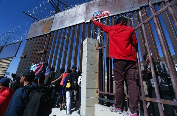Migrants at the U.S.-Mexico border fence on November 25, 2018, in Tijuana, Mexico.| Source: Getty Images.