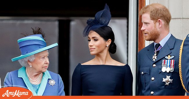The Queen, Duke and Duchess of Sussex watch the RAF flypast on the balcony of Buckingham Palace, as members of the Royal Family attend events to mark the centenary of the RAF on July 10, 2018 in London, England. | Source: Getty Images