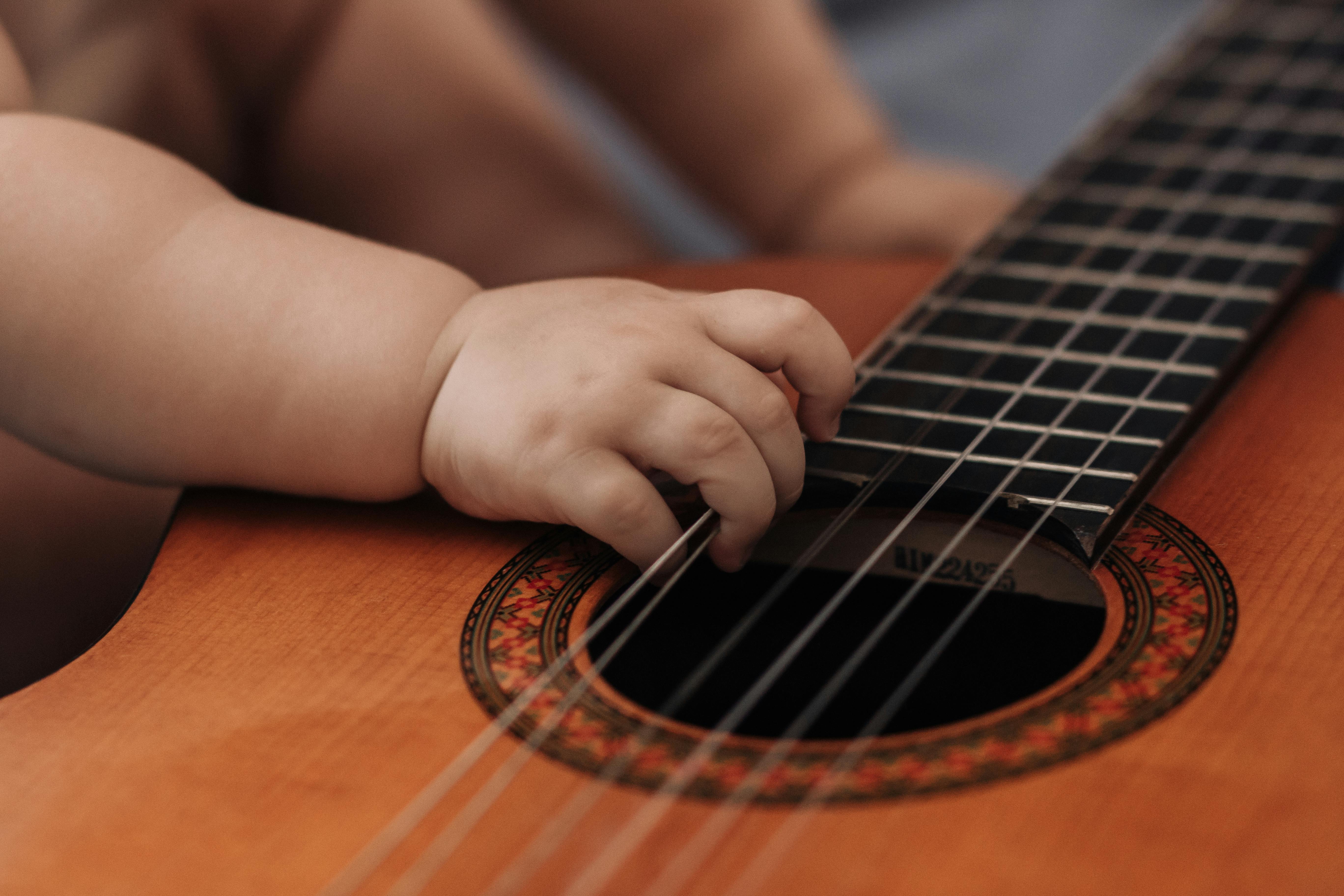 A baby's hand holding guitar strings | Source: Pexels
