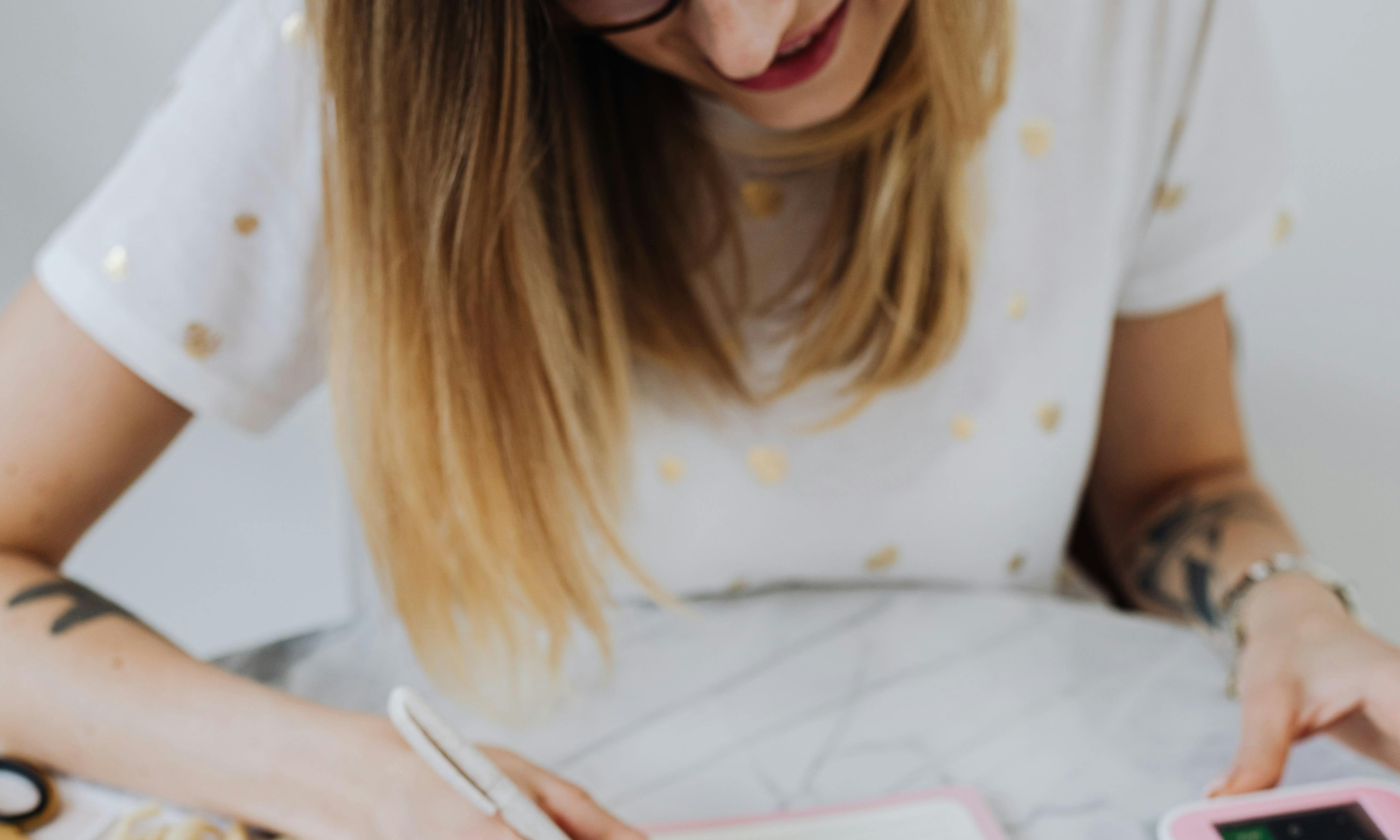 A woman making calculations with a pen in hand | Source: Pexels