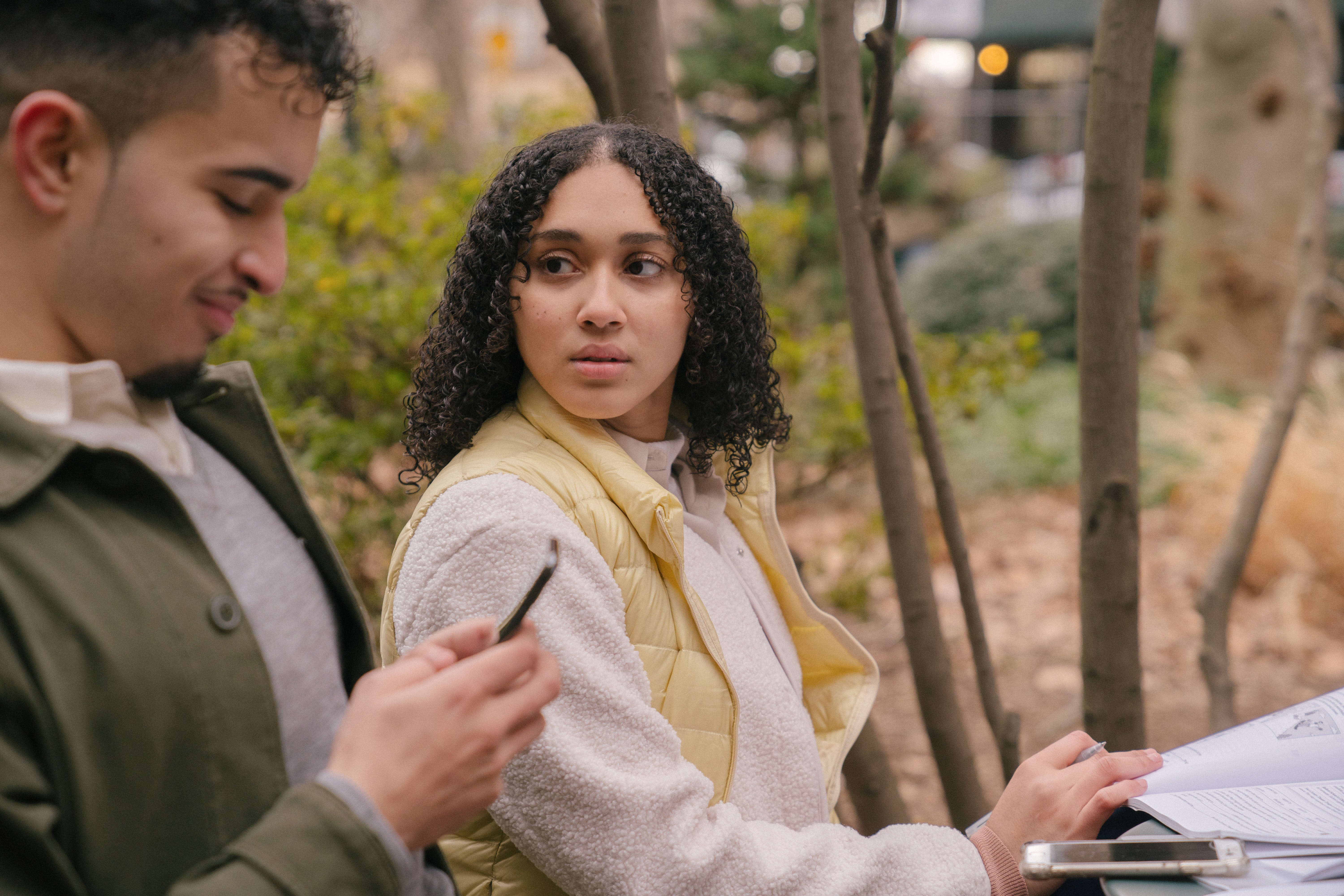 A woman looking at a man with a concerned face while he is texting. | Source: Pexels