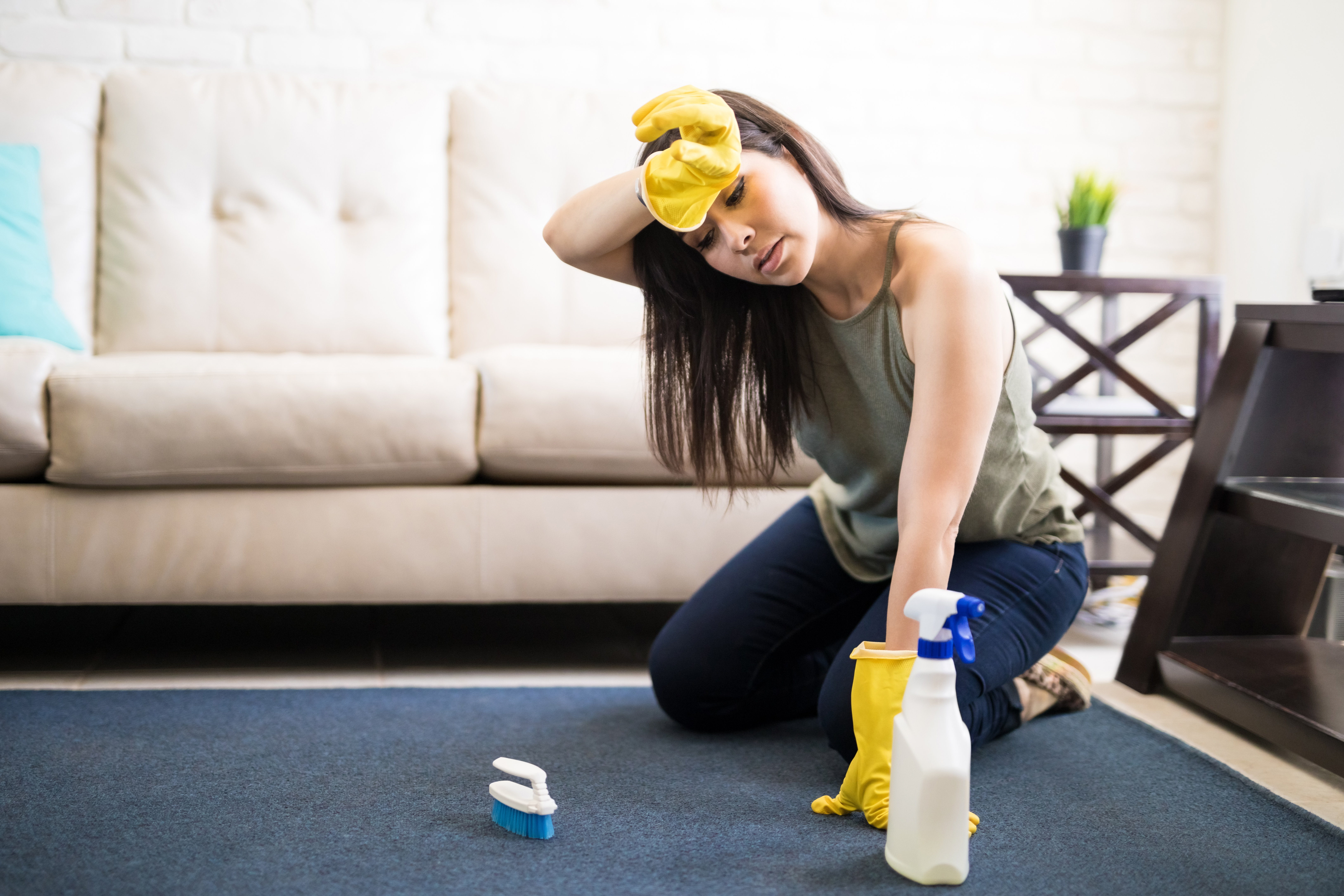 An exhausted woman cleaning a carpet | Source: Getty Images