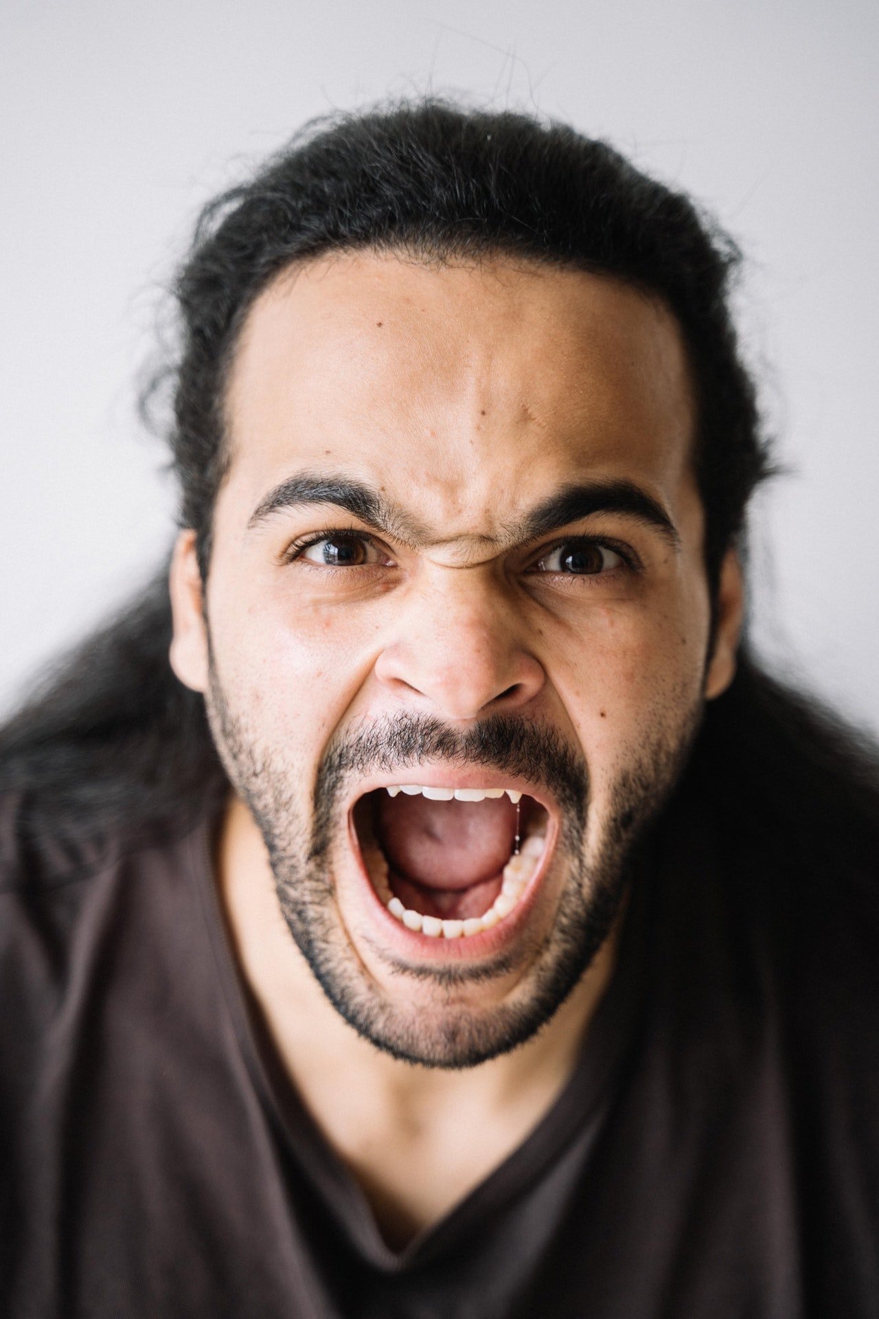 Un hombre joven parece gritar con furia. | Foto: Pexels