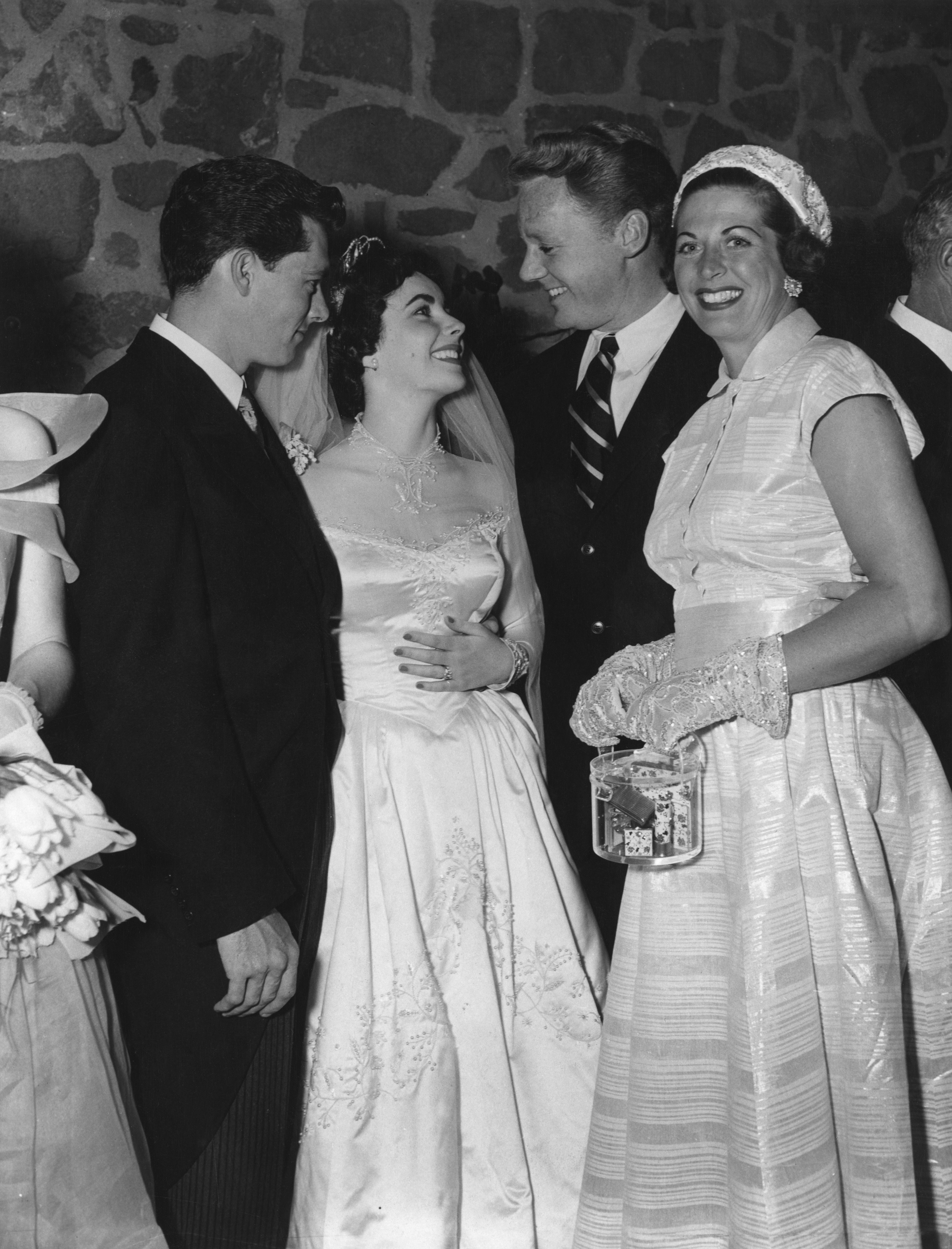 Screen star Van Johnson and his wife Evie (right) congratulate Elizabeth Taylor and her husband Conrad Hilton (left) at their wedding reception in Beverly Hills, Hollywood on 13th May 1950. | Source: Getty Images