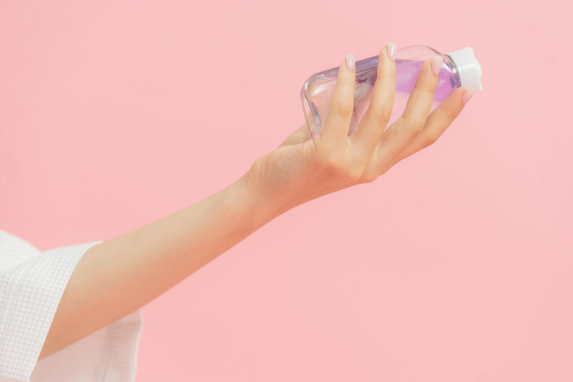 Woman holding a bottle of baby oil | Source: Pexels