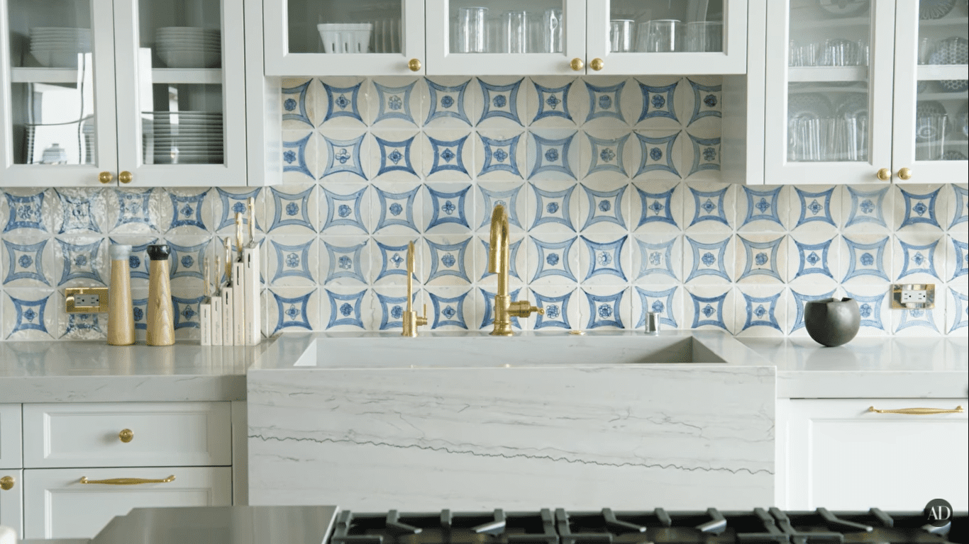 Gwyneth Paltrow's kitchen with contrasting elements featuring a farmhouse marble sink and blue tiles. / Source: YouTube.com/architecturaldigest