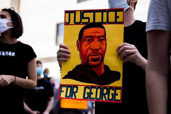 A protester holds a sign commemorating George Floyd during the Hollywood talent agencies march to support Black Lives Matter protests on June 06, 2020 in Beverly Hills, California | Photo: Getty Images