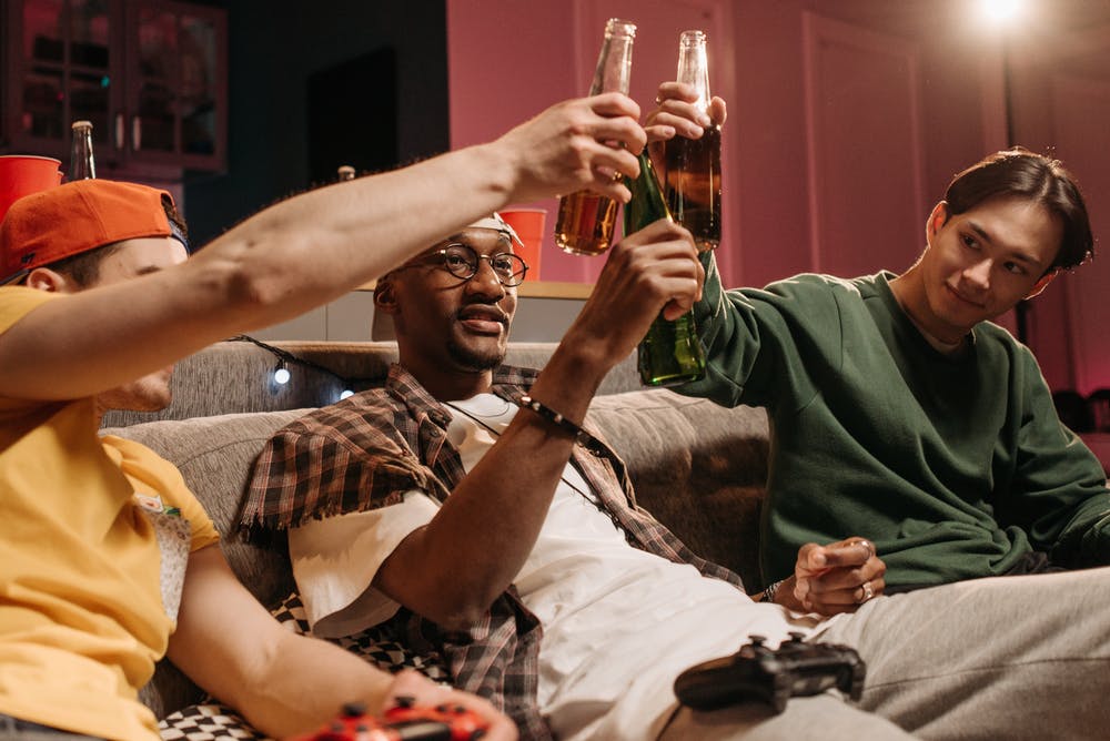 Three men drinking beer. | Photo: Pexels