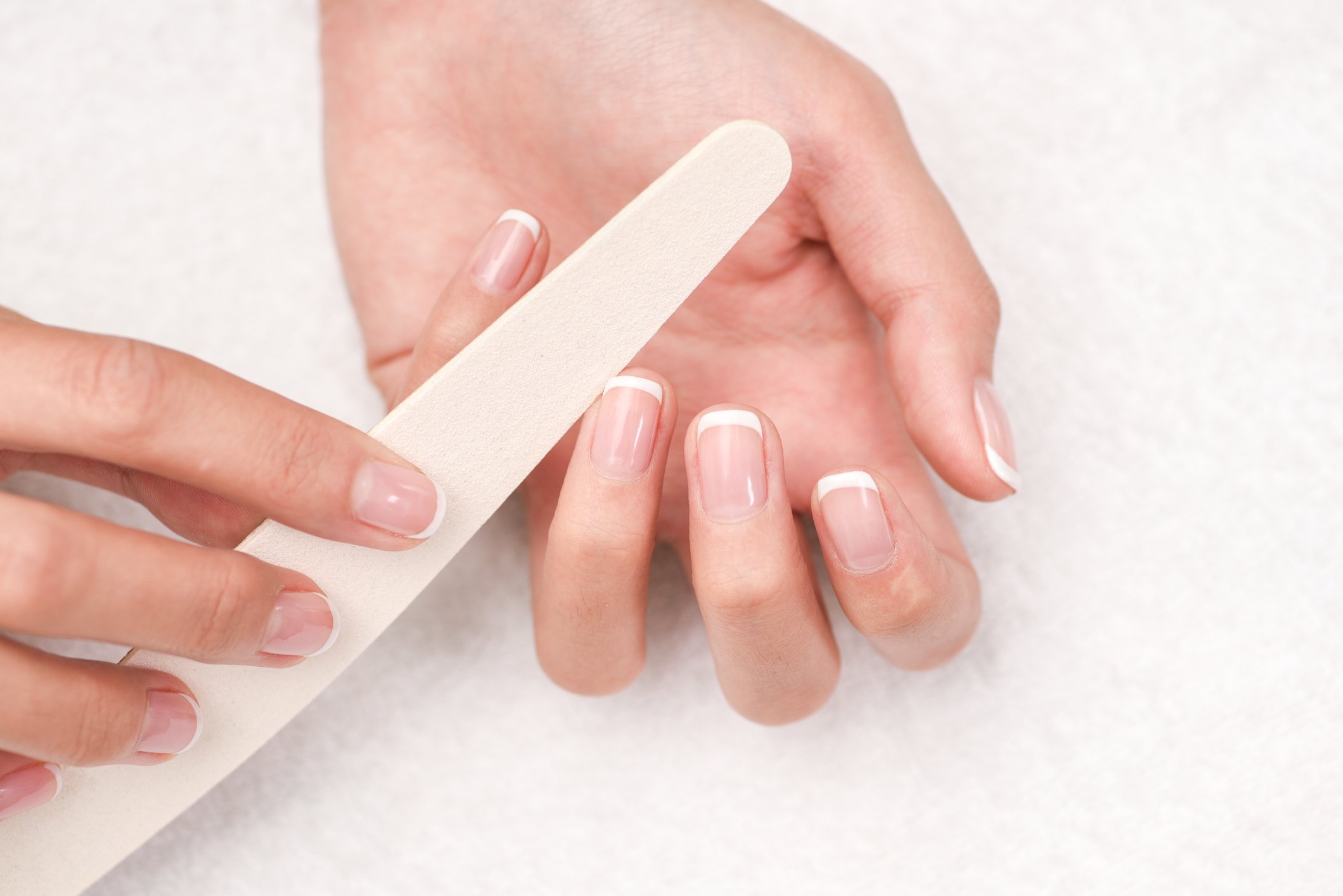 Jeune femme en train limer ses ongles. | Photo : Getty Images