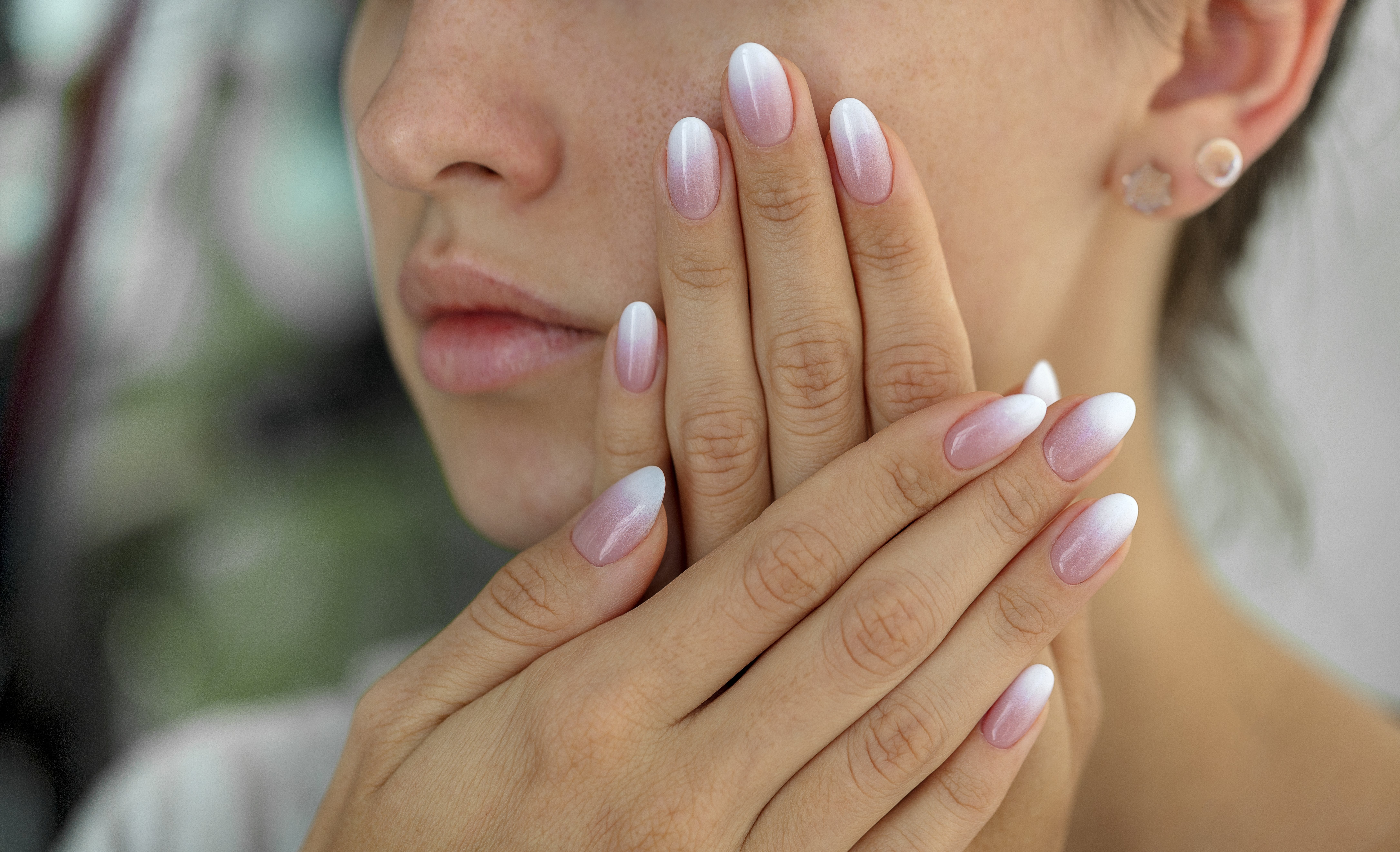Woman's nails with peach and white almond French ombre manicure. | Source: Getty Images