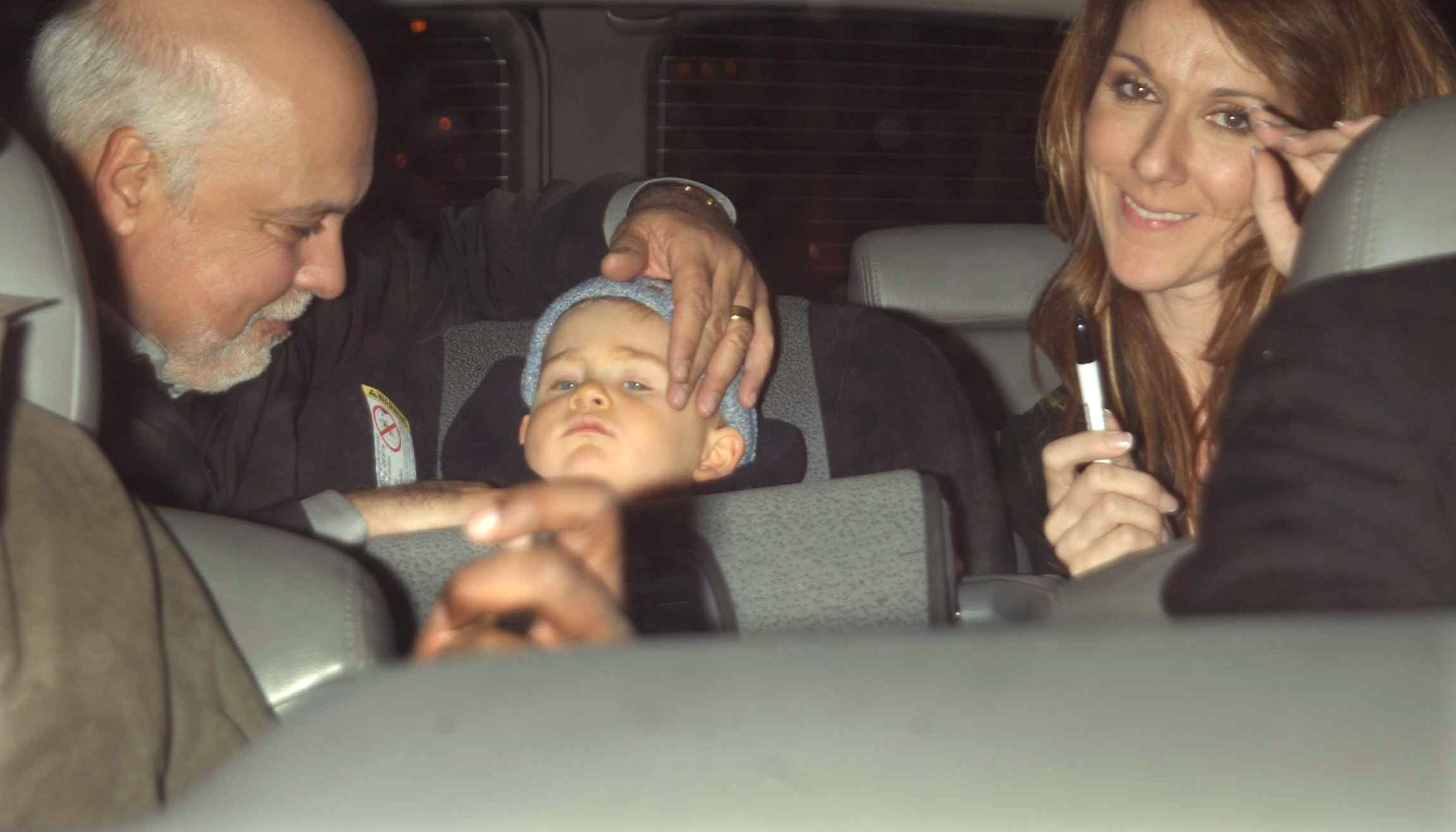 Rene Angelil, Rene-Charles and Celine Dion photographed inside a vehicle in New York City on March 27, 2002 | Source: Getty Images