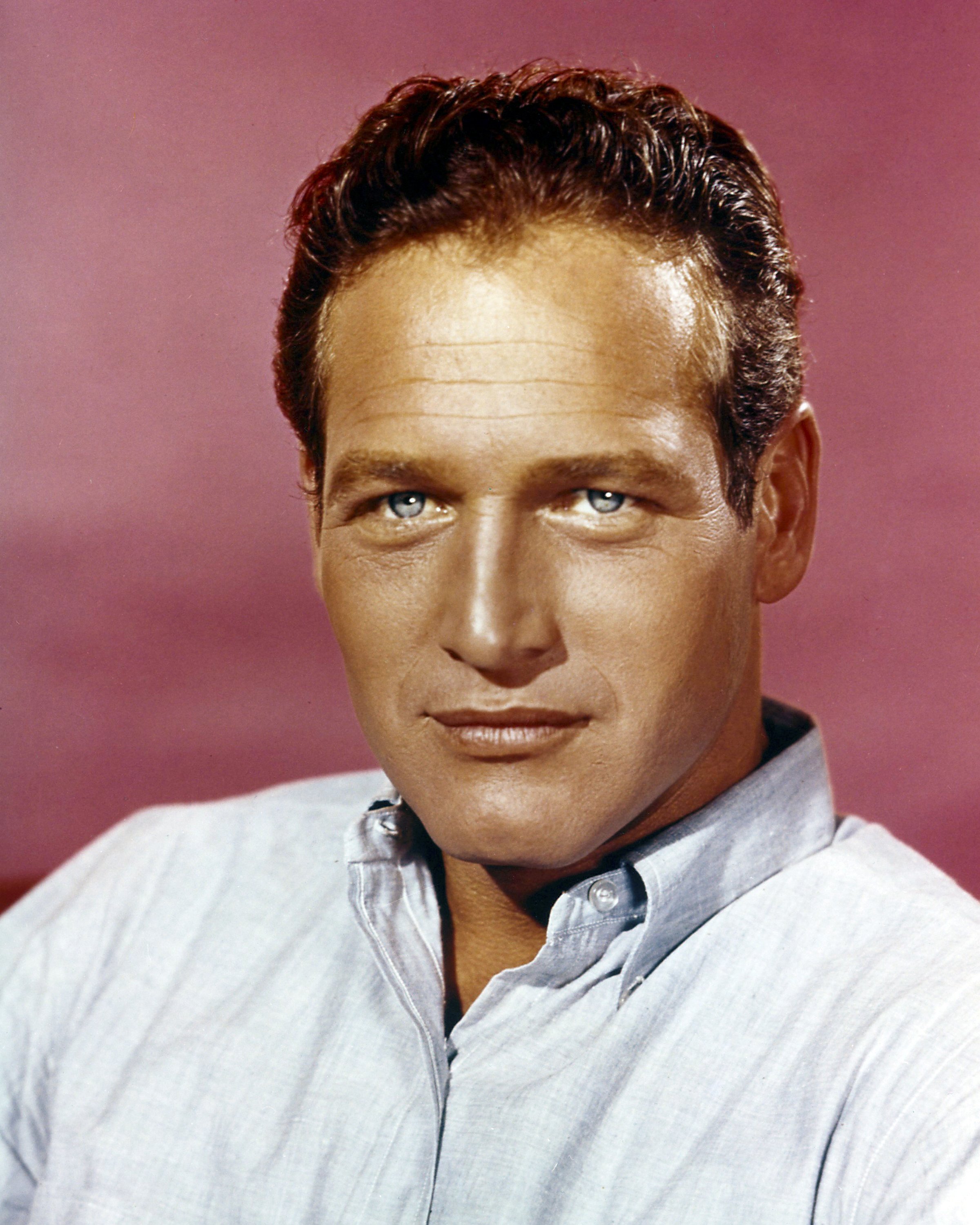 Portrait of American film director Paul Newman as he poses against a pale red background in the 1960s | Photo: Getty Images