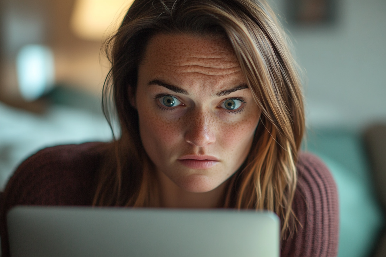 A woman looking at her laptop screen | Source: Midjourney