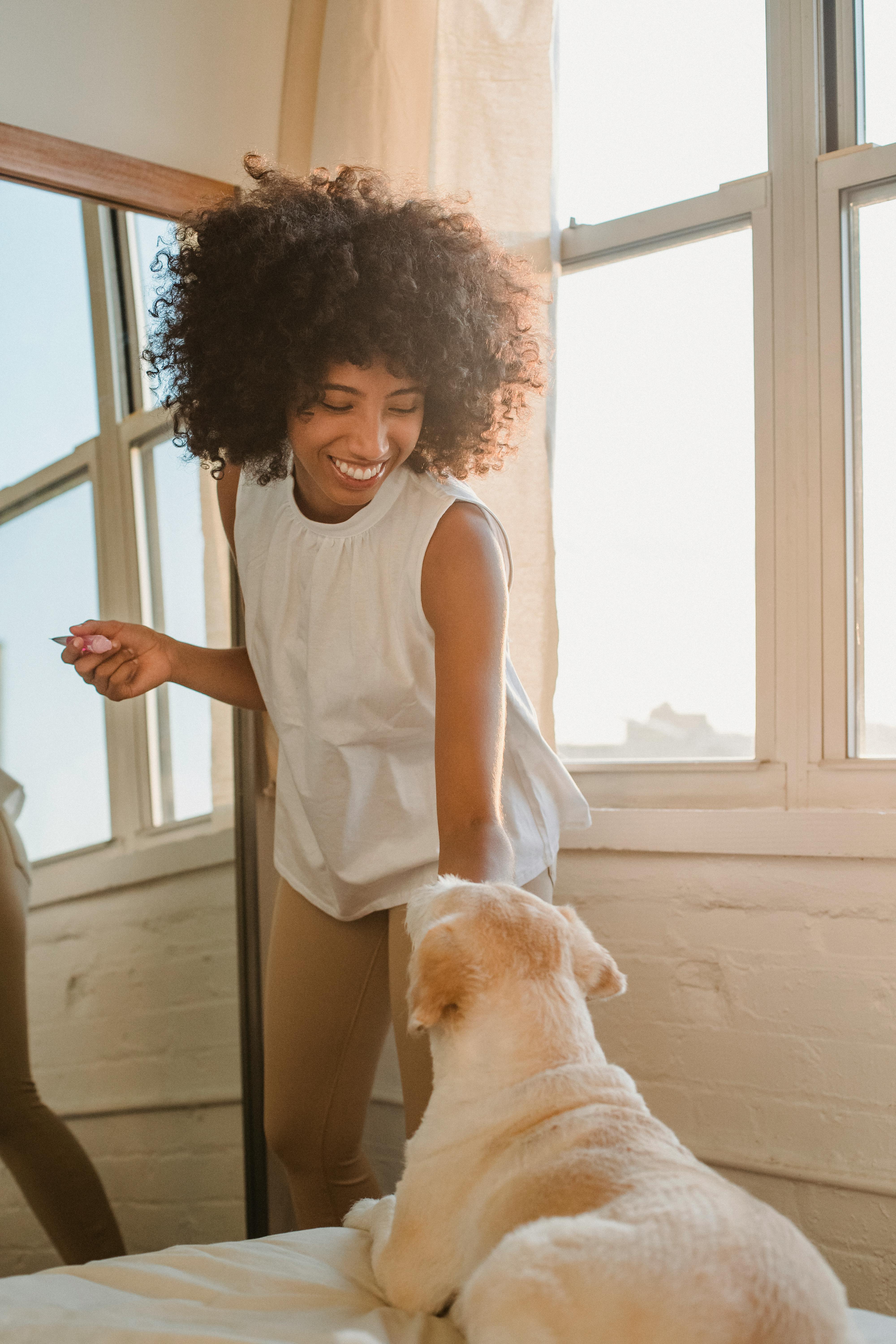 Una mujer sonriendo a su perro | Fuente: Pexels