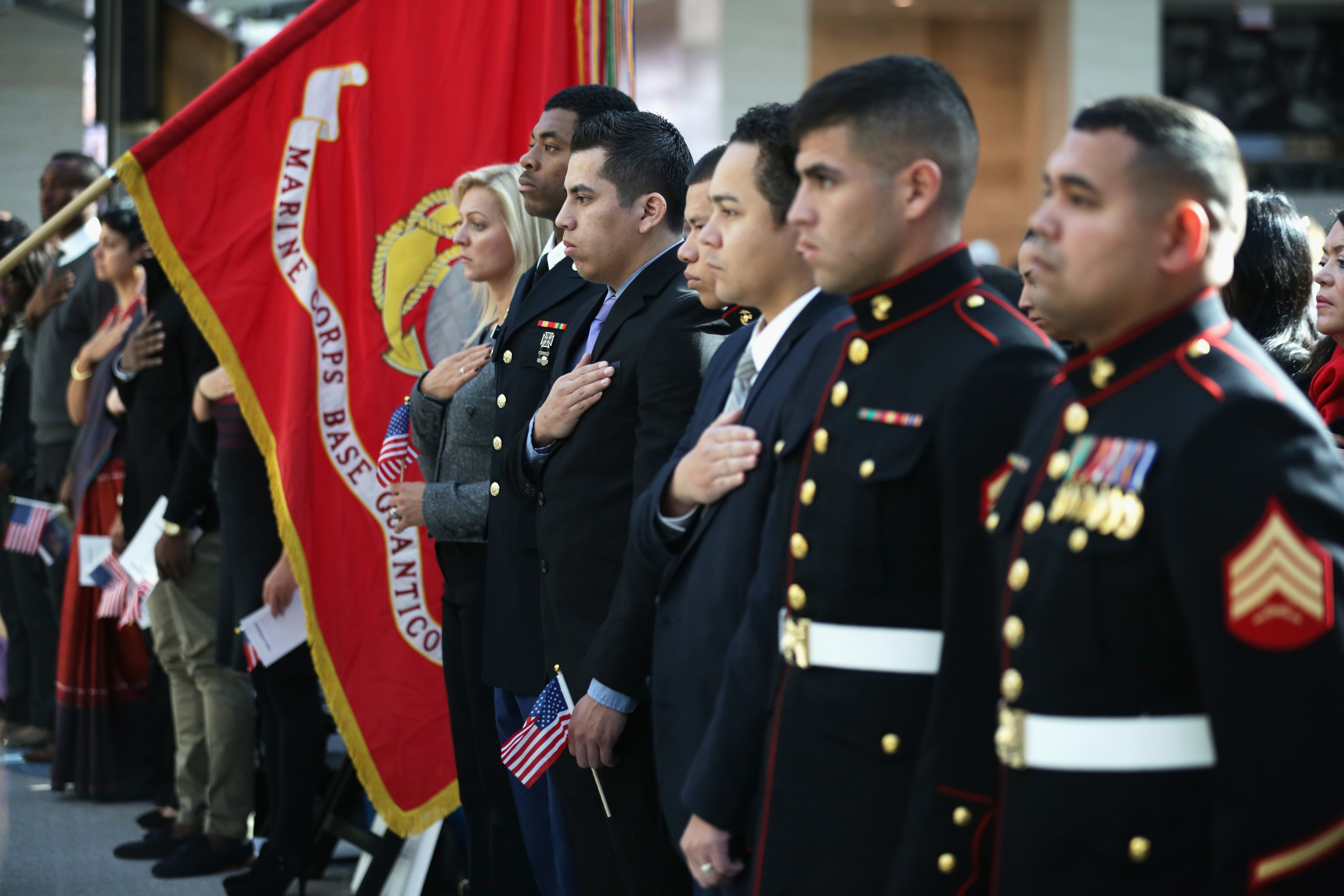 New citizens listen to the national anthem during a naturalization ceremony at the National Museum of the Marine Corps in Triangle, Virginia, on November 10, 2014 | Source: Getty Images