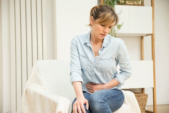 Woman clutching her stomach | Image: Getty Images