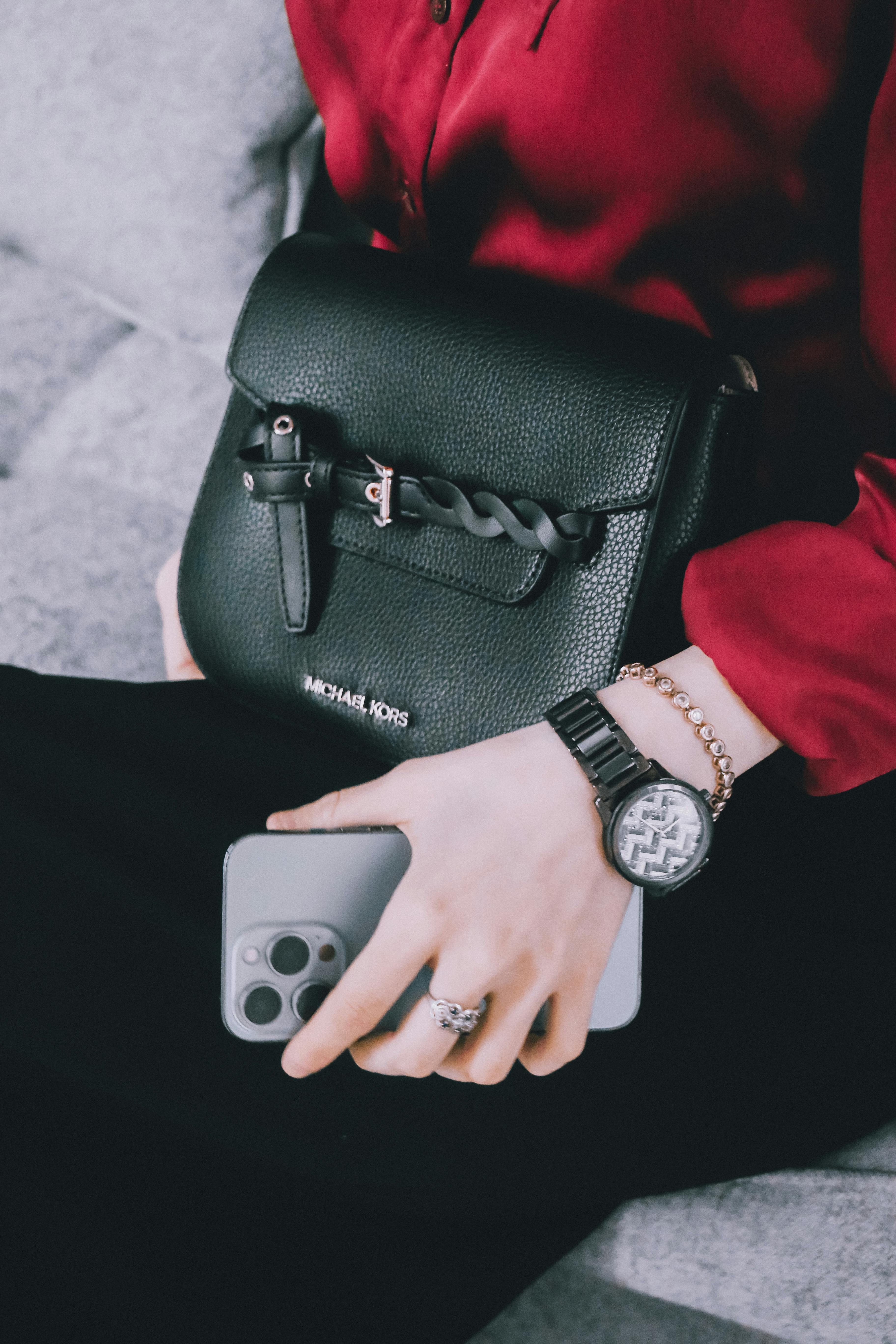 A woman with an expensive watch, jewelry, phone, and bag | Source: Pexels