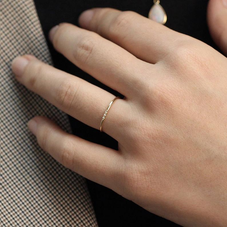 Minimalist Wedding Band from JSVConcepts Fine Jewelry in Gold featuring one three diamonds. | Source: Etsy.com