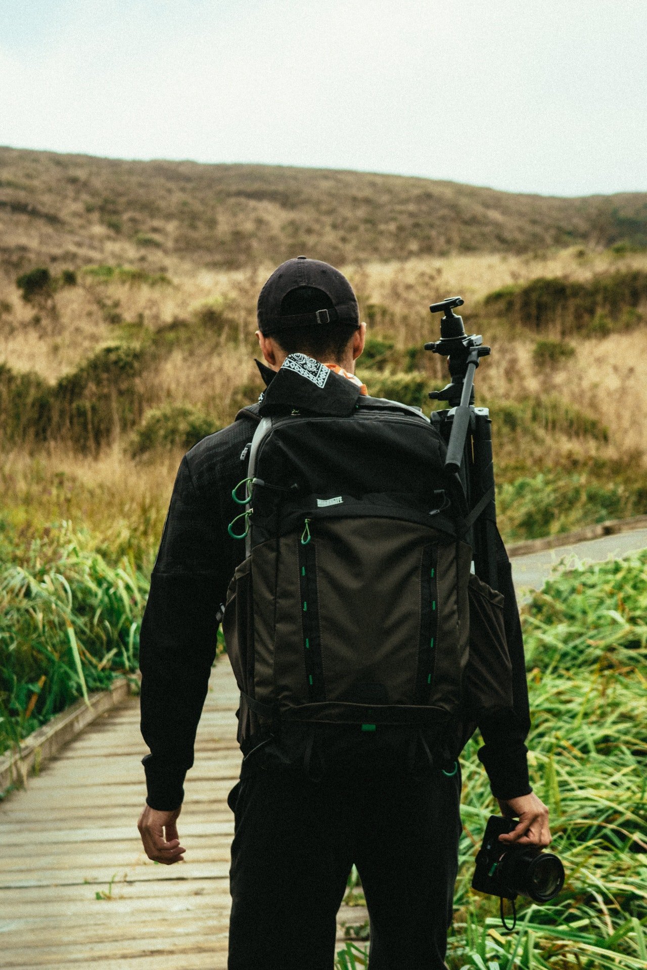 Photo of a man trekking while wearing a black backpack | Photo: Pexels