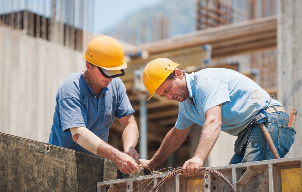 Zwei Bauarbeiter auf der Baustelle eines Projekts. | Quelle: Shutterstock