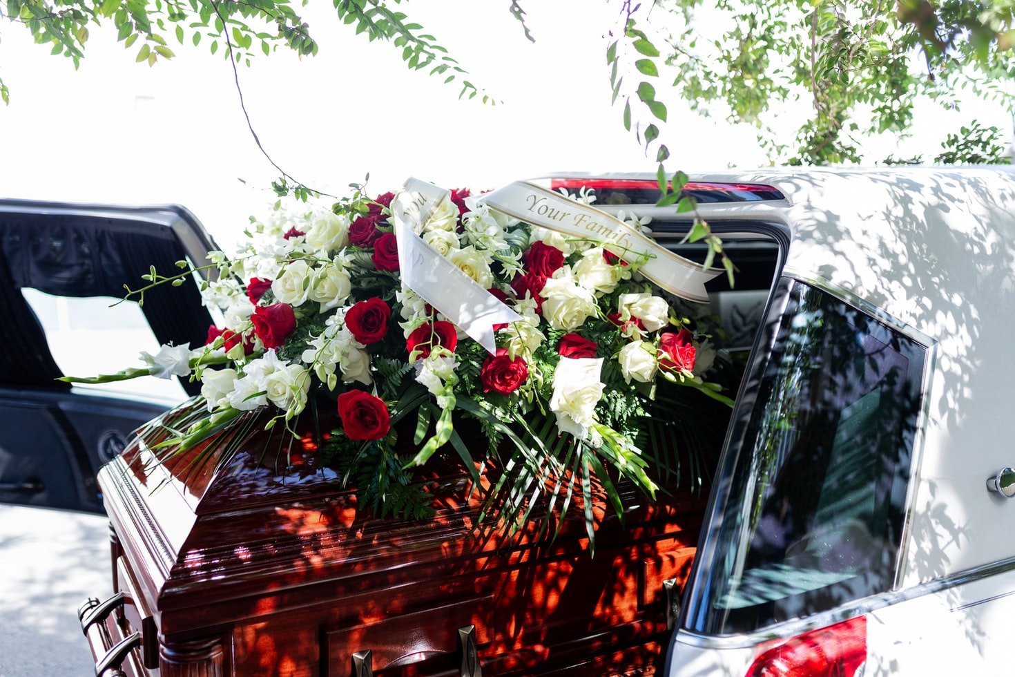Un carro fúnebre traslada un ataud con flores en su superficie. | Foto: Unsplash