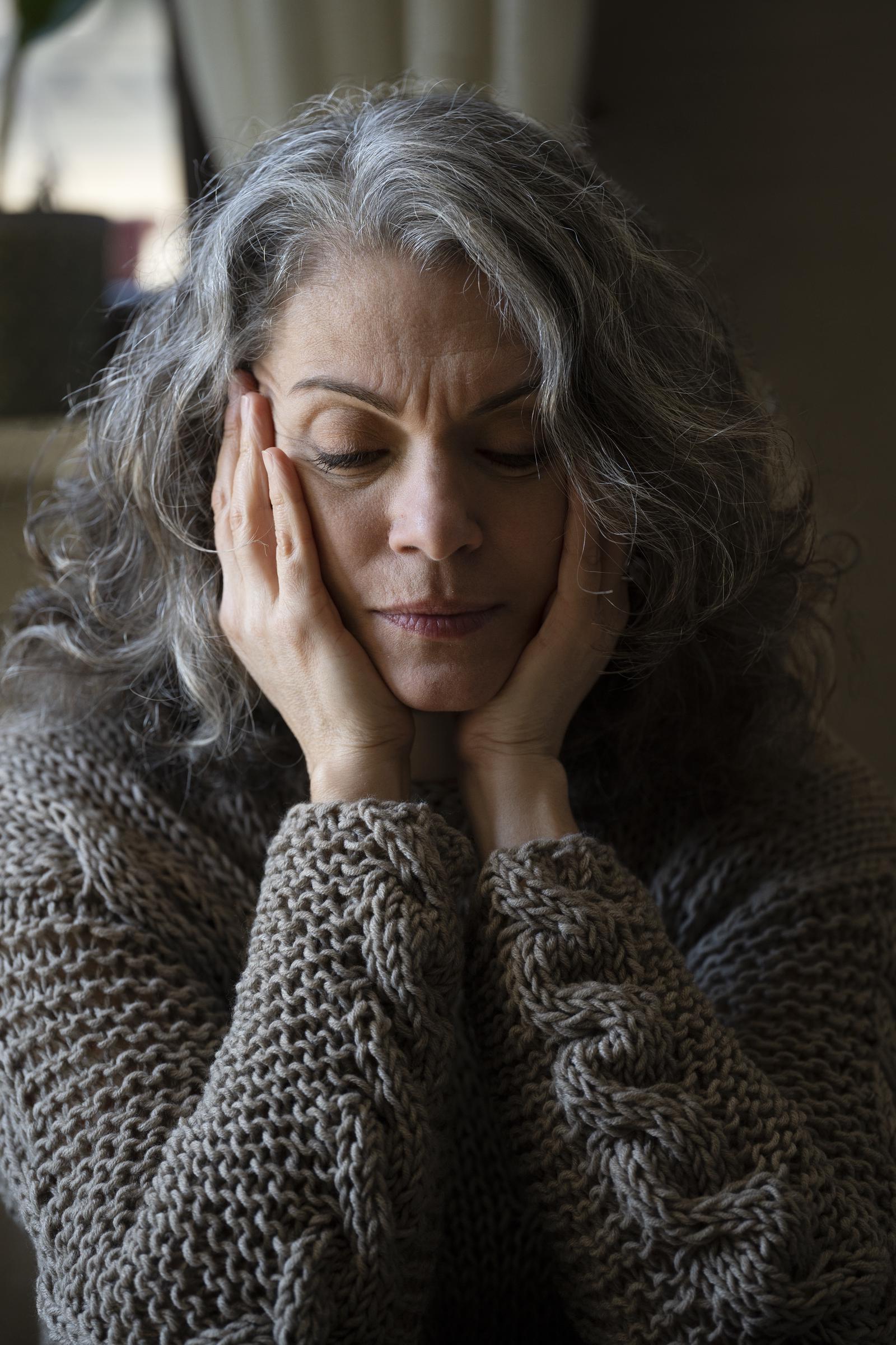 An elderly woman with her eyes closed | Source: Freepik