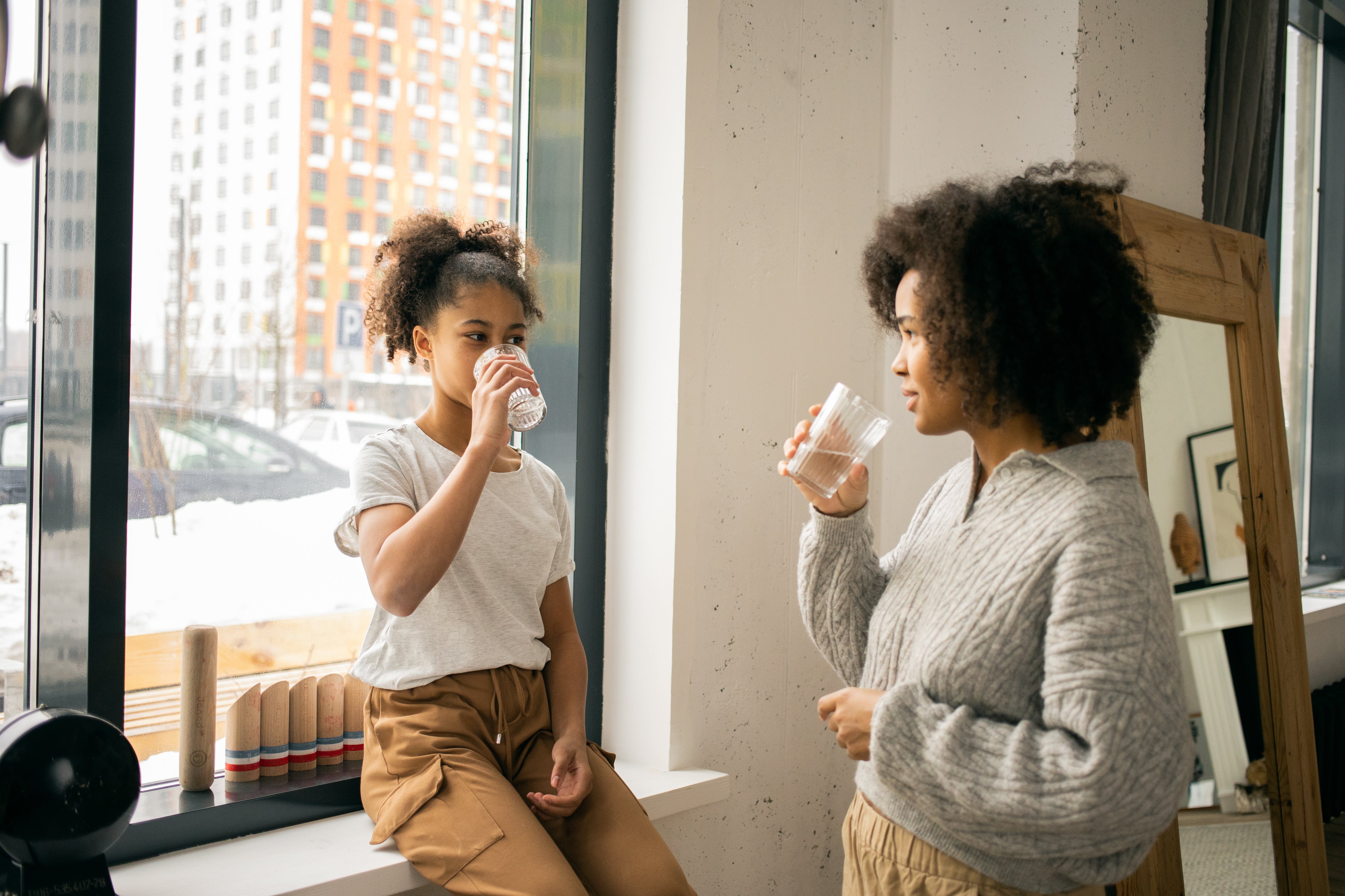 Mom and daughter drinking water. | Source: Pexels